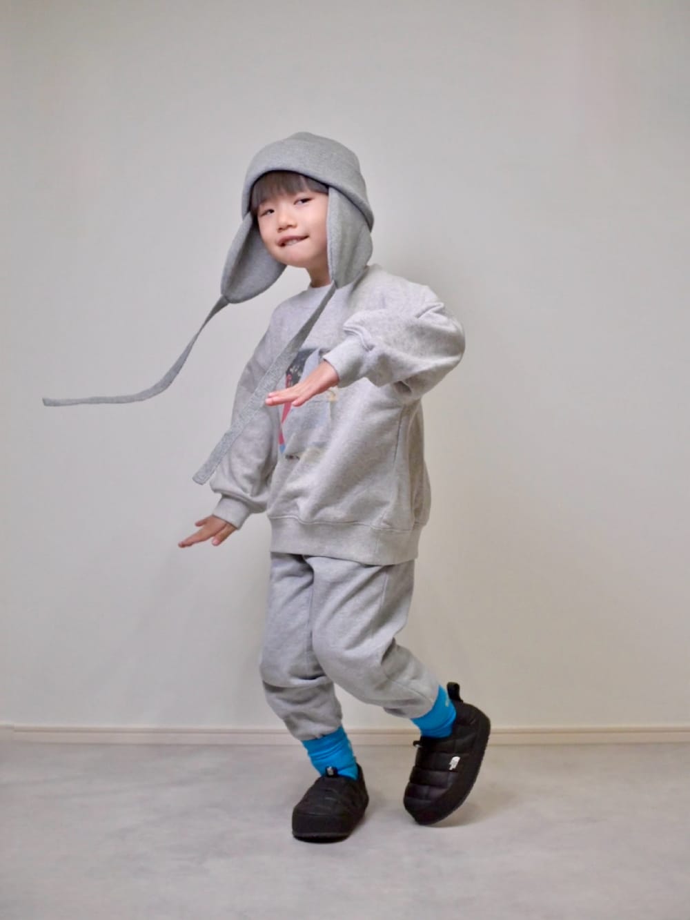 グレー系のスウェット、グレー系のスウェットパンツ、ブラック系のスニーカーを着用したキッズの冬コーディネートの2枚目の写真