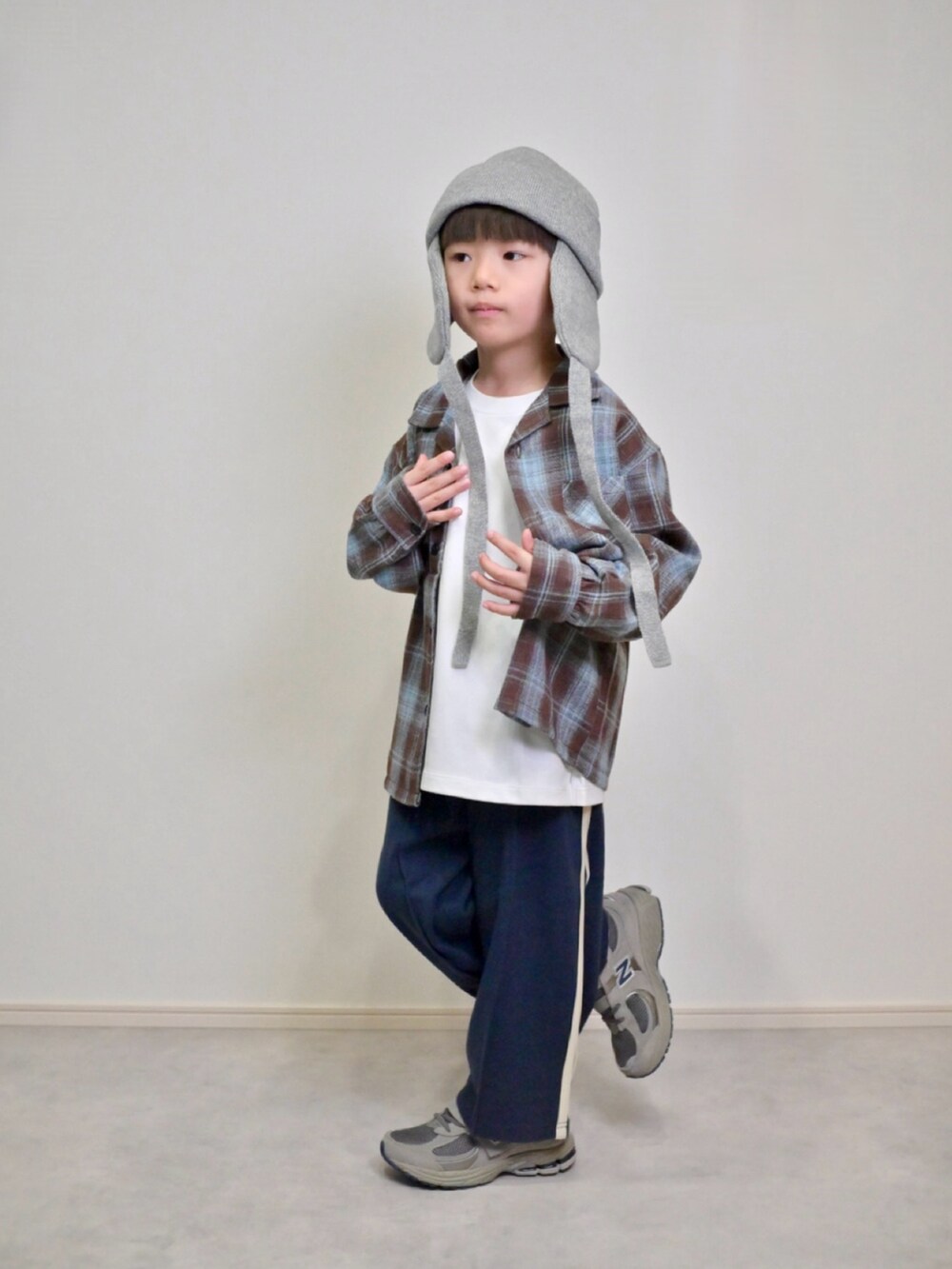 グレー系のスニーカー、ブルー系のその他パンツ、ブラウン系のセットアップを着用したキッズの秋コーディネートの4枚目の写真