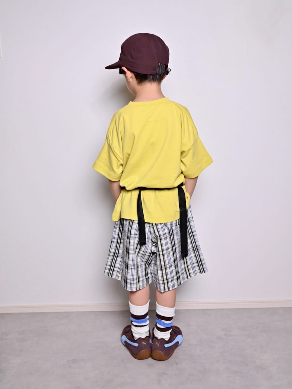 イエロー系のTシャツ/カットソー、ホワイト系のチノパンツ、ブラウン系のスニーカーを着用したキッズの春コーディネートの3枚目の写真