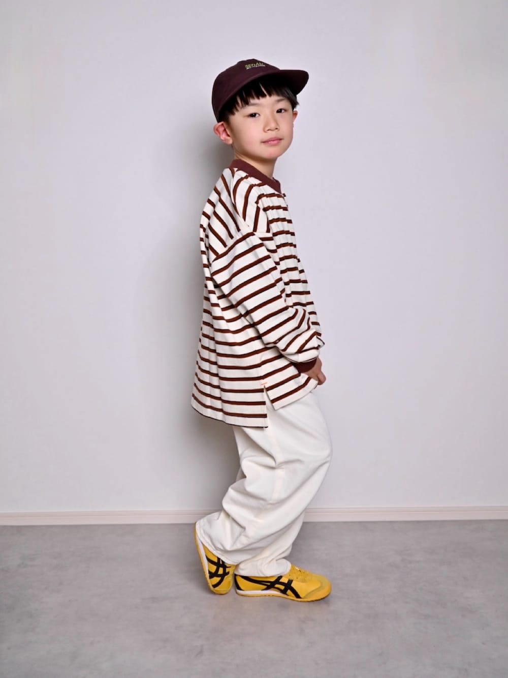 ホワイト系のTシャツ/カットソー、イエロー系のスニーカー、イエロー系のベルトを着用したキッズの春コーディネートの3枚目の写真