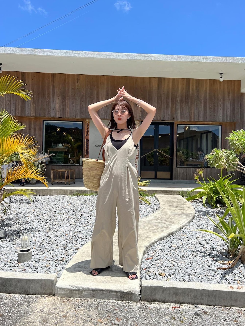 ベージュ系のオールインワン・サロペット、ベージュ系のかごバッグを着用したレディースの夏コーディネートの3枚目の写真