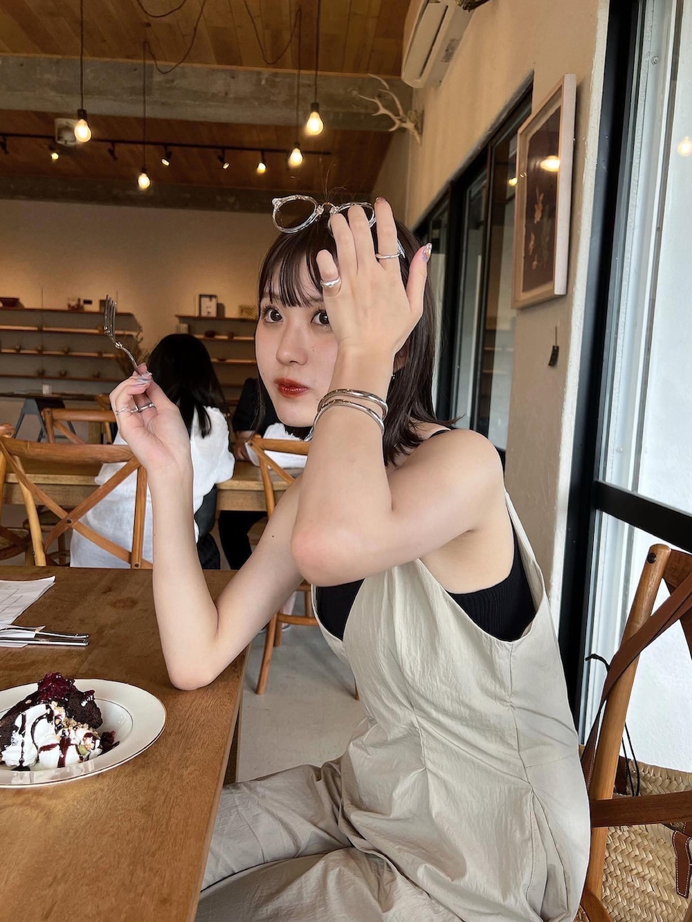 ベージュ系のオールインワン・サロペット、ベージュ系のかごバッグを着用したレディースの夏コーディネートの5枚目の写真