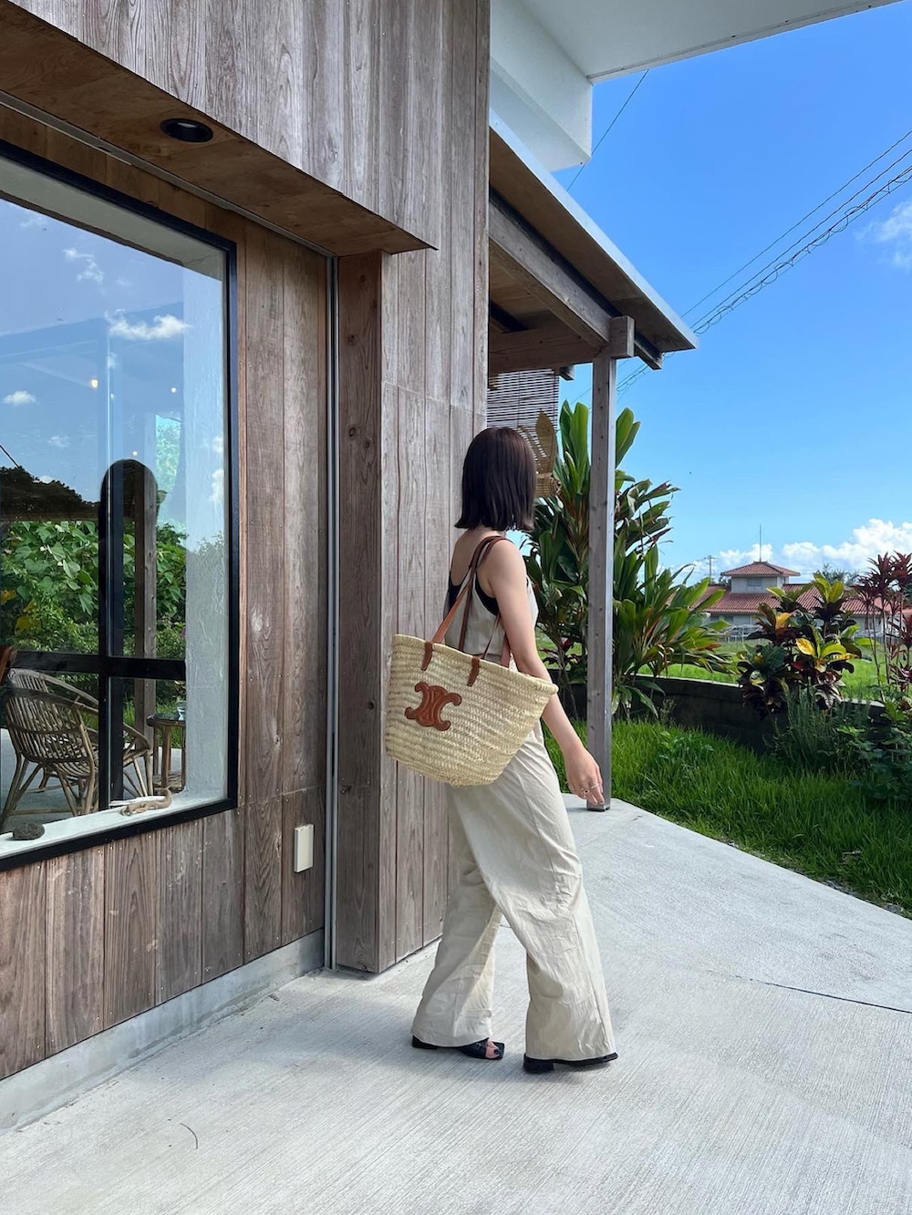 ベージュ系のオールインワン・サロペット、ベージュ系のかごバッグを着用したレディースの夏コーディネートの2枚目の写真