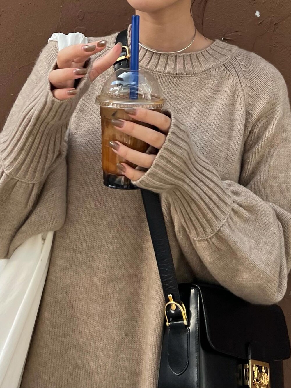 ベージュ系のワンピース、ホワイト系のトートバッグ、ブラック系のバッグを着用したレディースの秋コーディネートの3枚目の写真