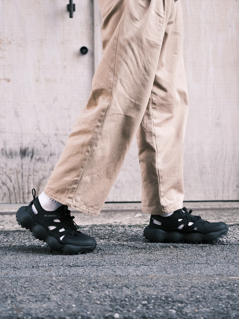 ブラック系のサンダル、ベージュ系のチノパンツ、ブラック系のナイロンジャケットを着用したメンズの春コーディネートの2枚目の写真