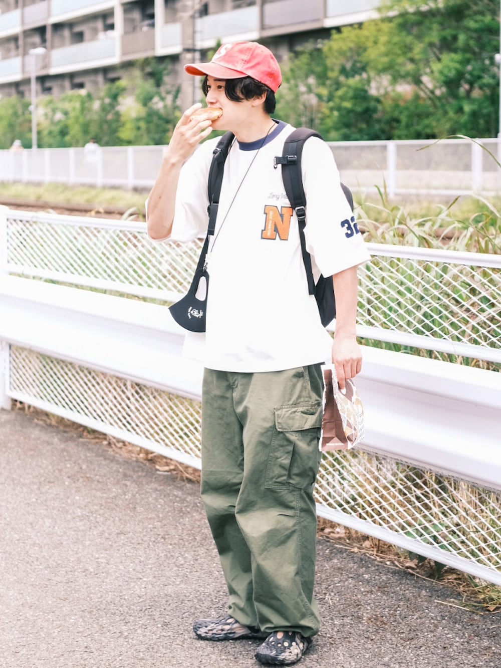 ホワイト系のTシャツ/カットソー、グリーン系のカーゴパンツ、ブラック系のサンダルを着用したメンズの夏コーディネートの3枚目の写真