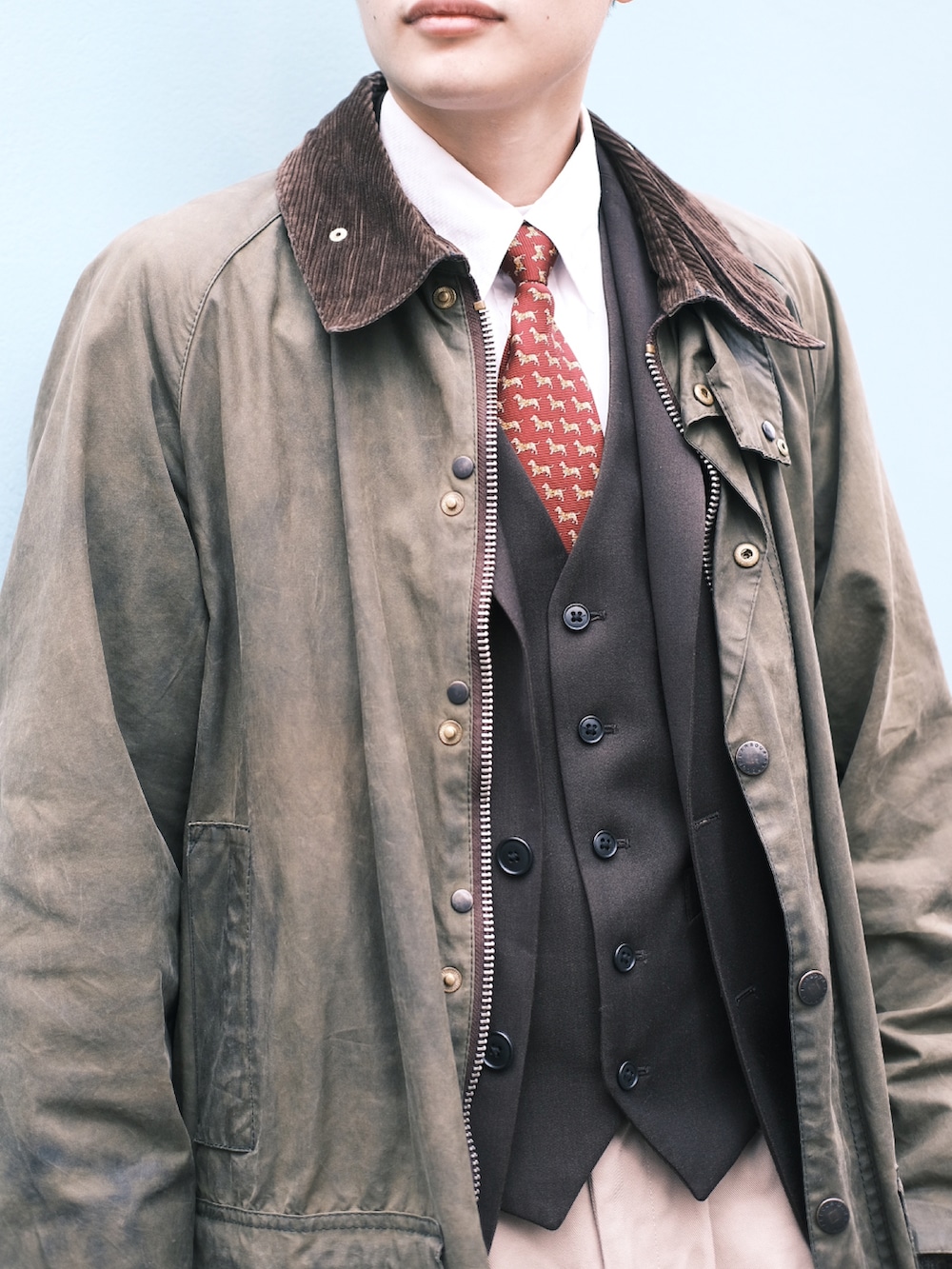 グリーン系のブルゾン、ブラウン系のスーツベスト、ブラウン系のスーツジャケットを着用したメンズの冬コーディネートの2枚目の写真