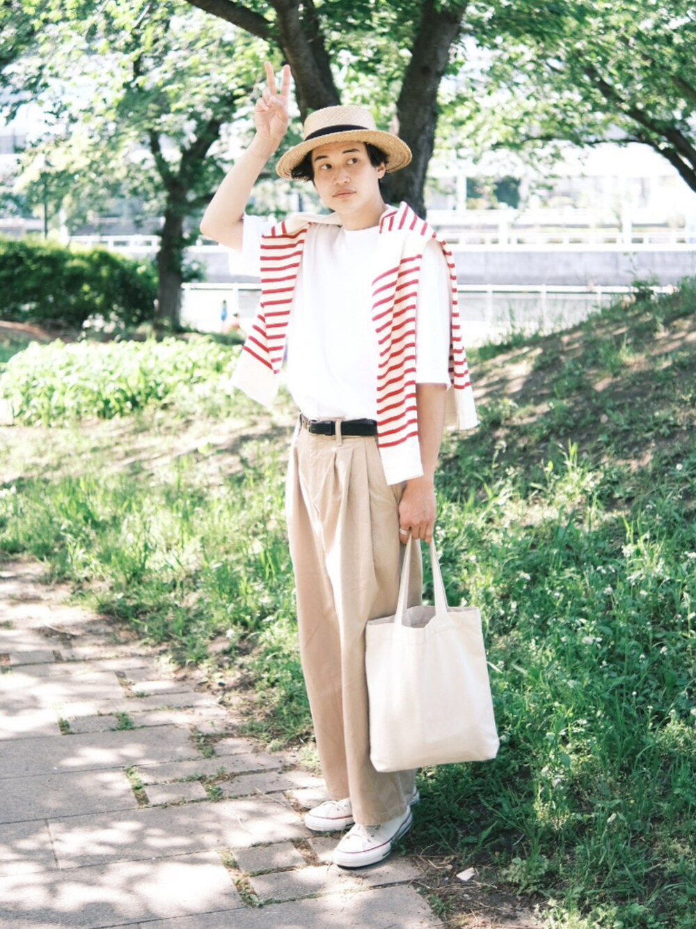 レッド系のTシャツ/カットソー、ホワイト系のTシャツ/カットソー、ベージュ系のチノパンツを着用したメンズの春コーディネートの2枚目の写真