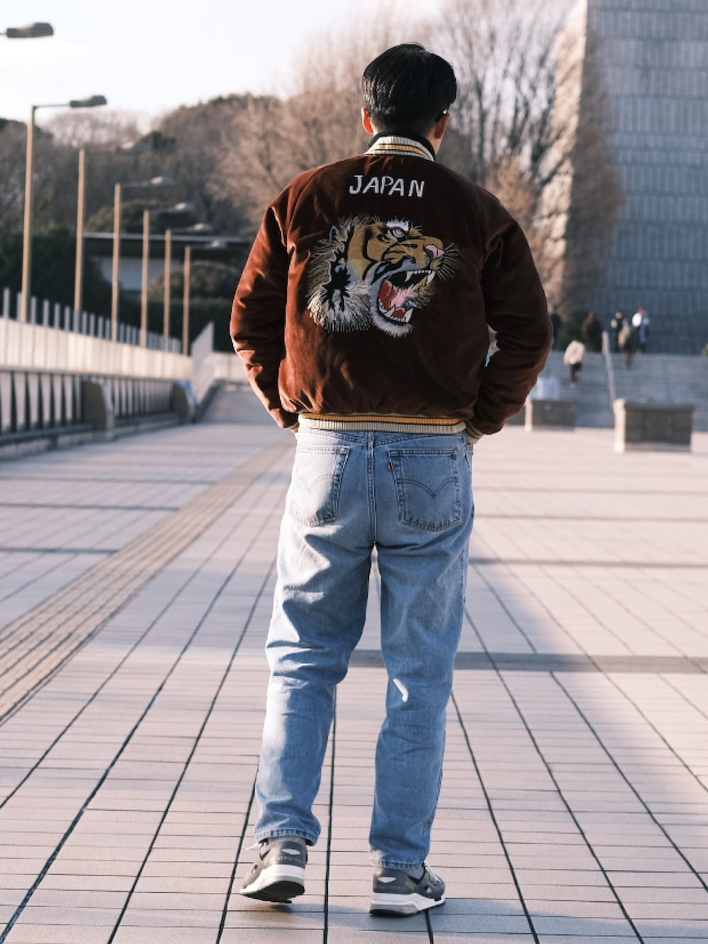 ブラウン系のスカジャン、グレー系のスニーカーを着用したメンズの冬コーディネートの2枚目の写真