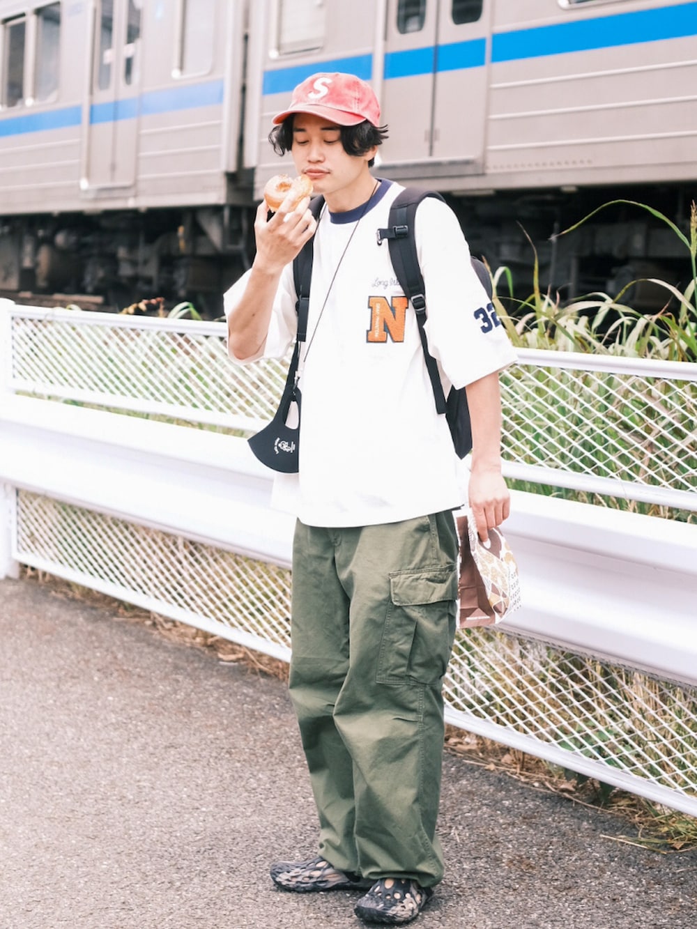 ホワイト系のTシャツ/カットソー、グリーン系のカーゴパンツ、ブラック系のサンダルを着用したメンズの夏コーディネートの2枚目の写真
