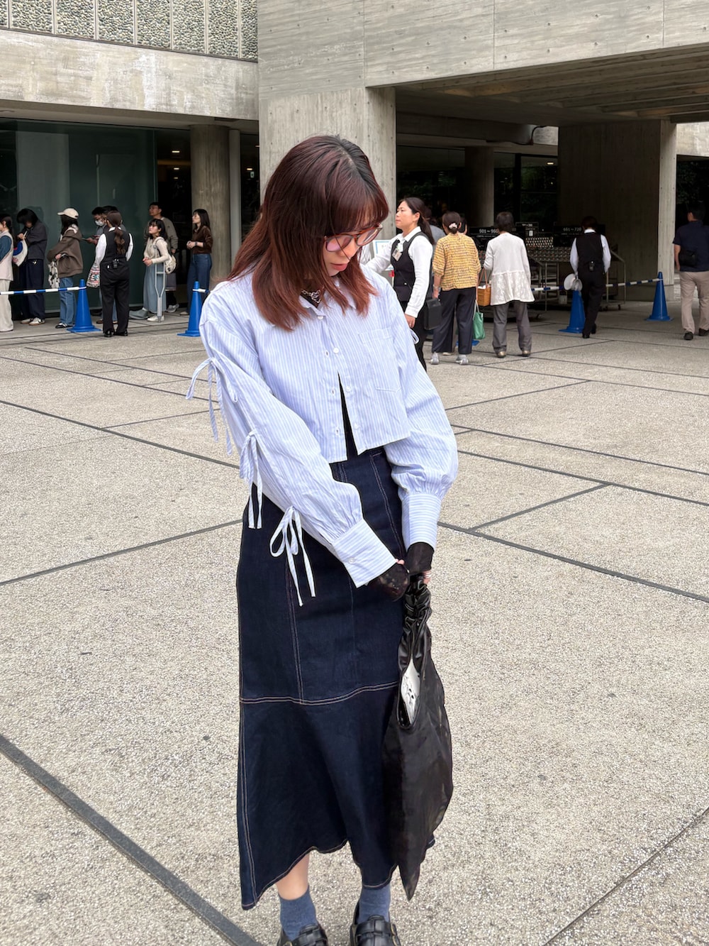 ブルー系のデニムスカート、ブルー系のシャツ/ブラウス、ブラック系のTシャツ/カットソーを着用したレディースの夏コーディネートの2枚目の写真