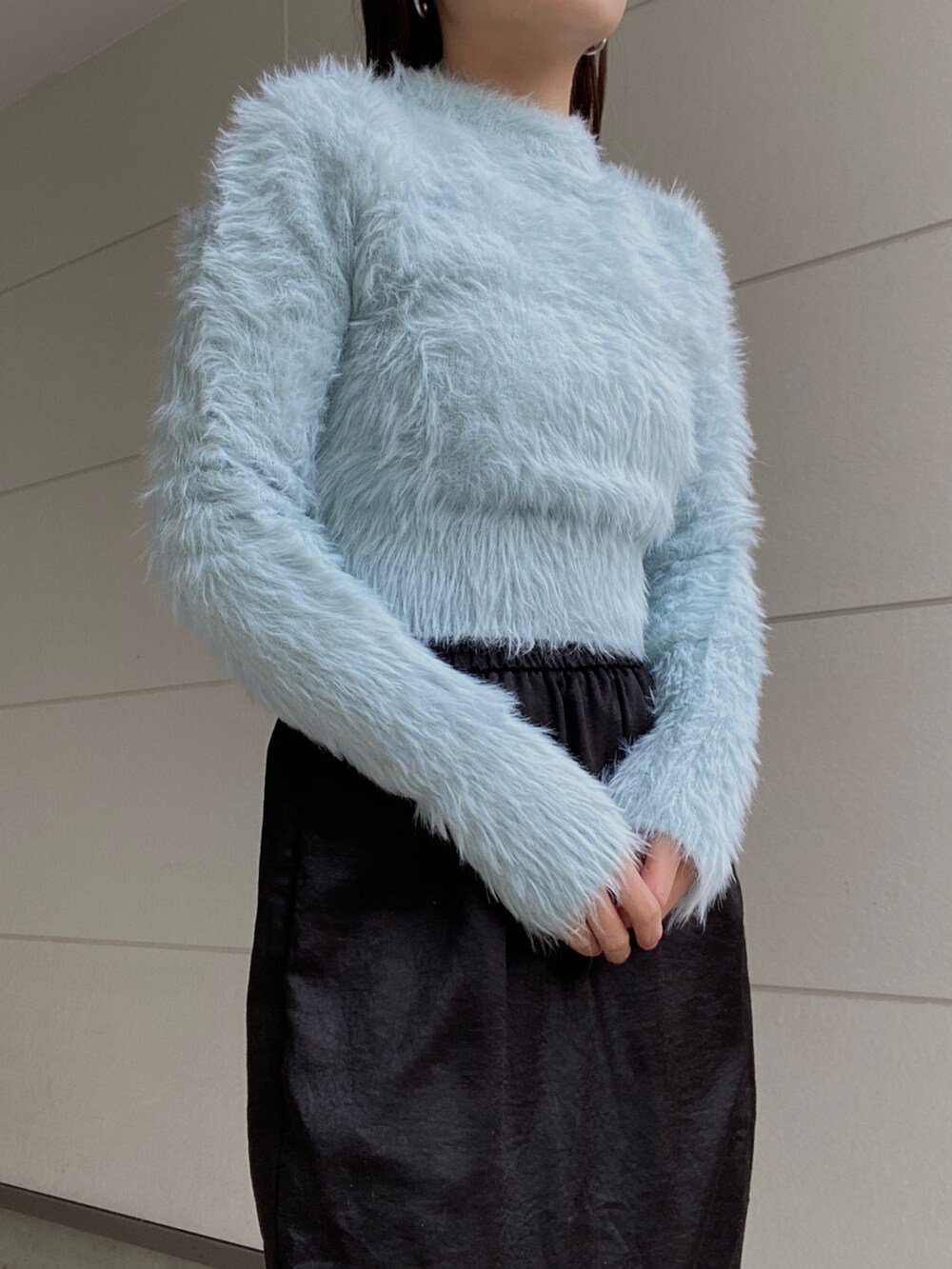 ブラック系のダウンジャケット/コート、ブルー系のニット/セーター、ブラック系のスカートを着用したレディースの冬コーディネートの4枚目の写真