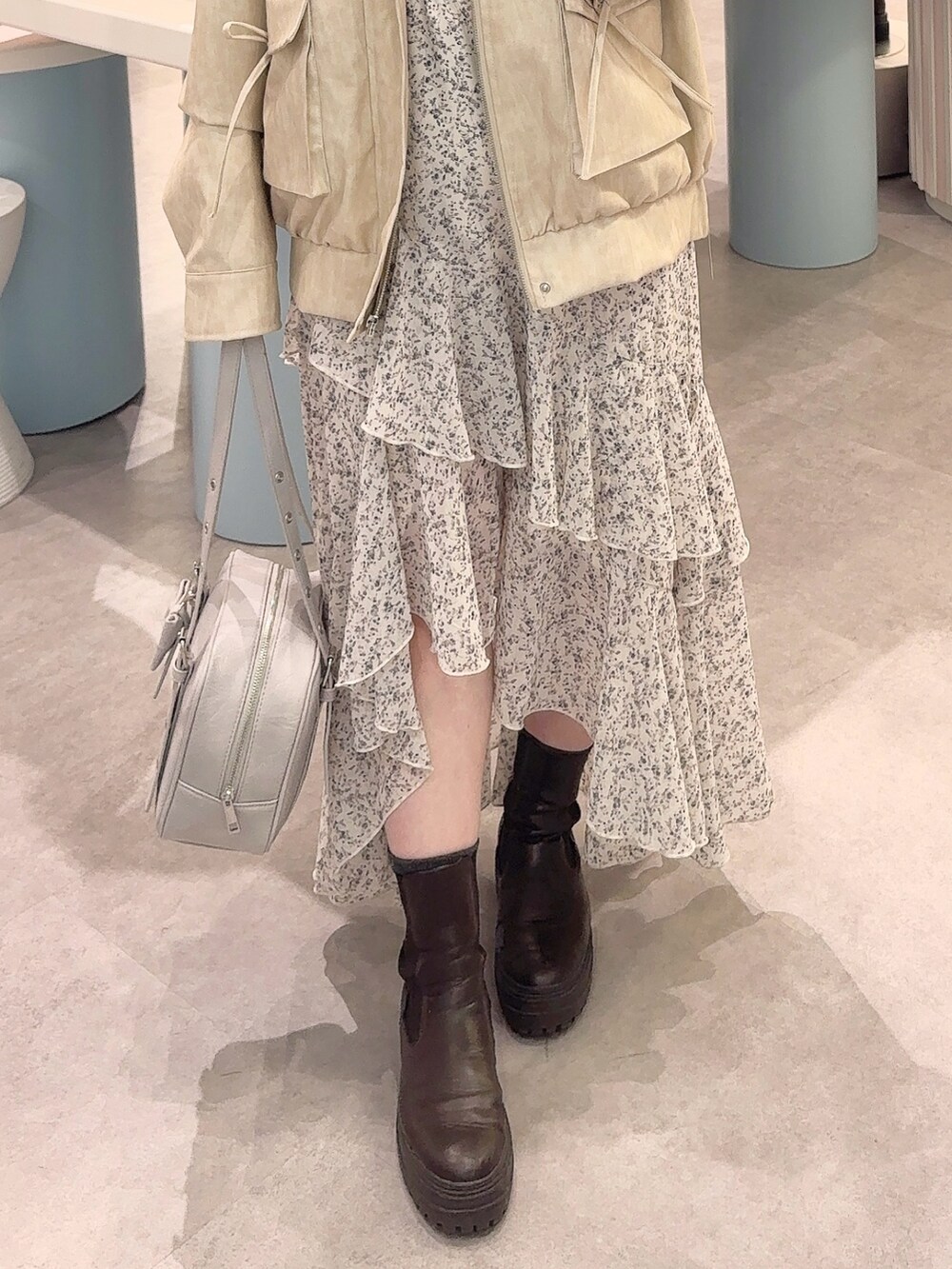 ホワイト系のブルゾン、ホワイト系のワンピース、ブルー系のショルダーバッグを着用したレディースの冬コーディネートの3枚目の写真