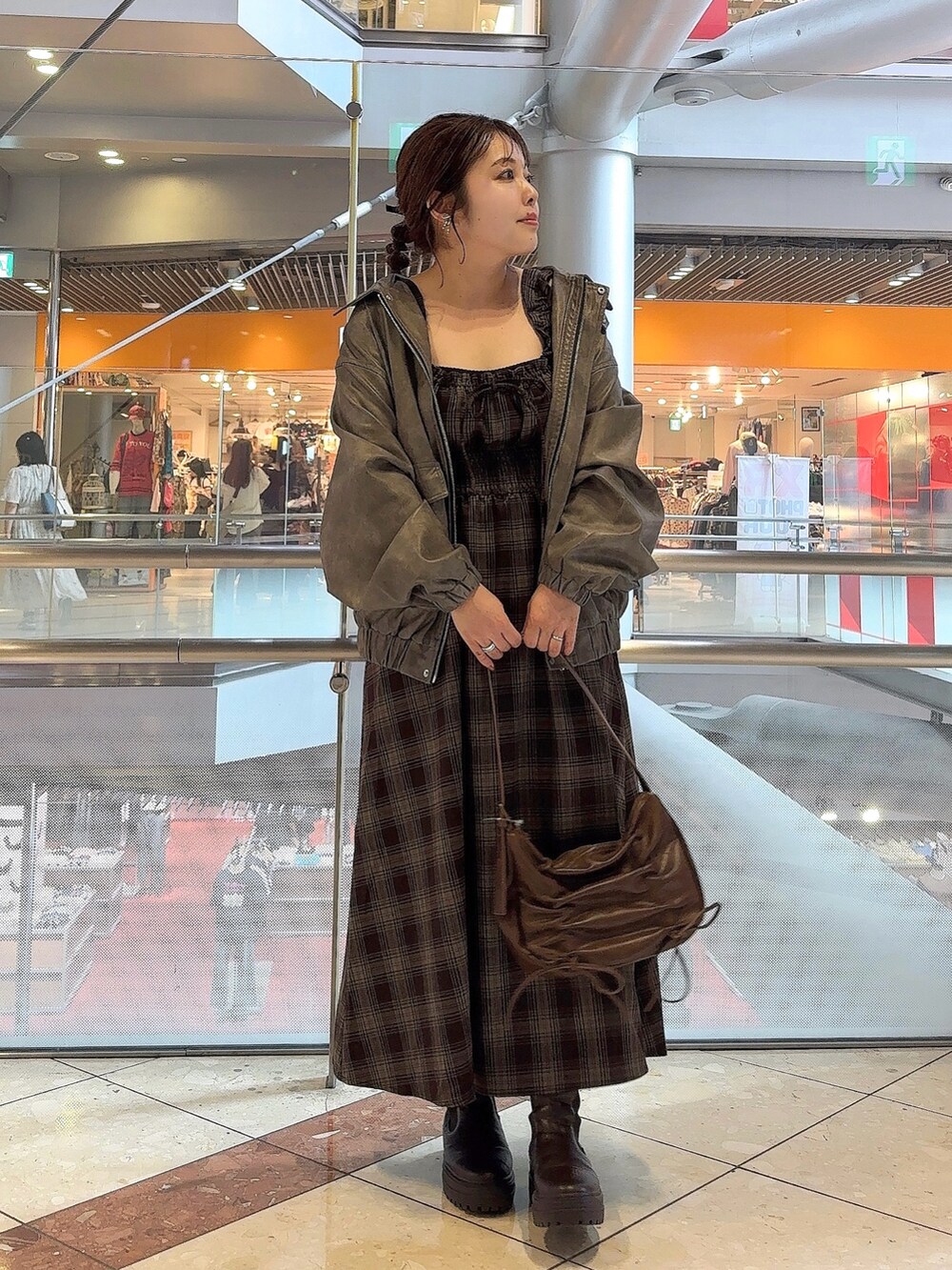 グレー系のブルゾン、その他のワンピース、ブラウン系のショルダーバッグを着用したレディースの秋コーディネートの2枚目の写真