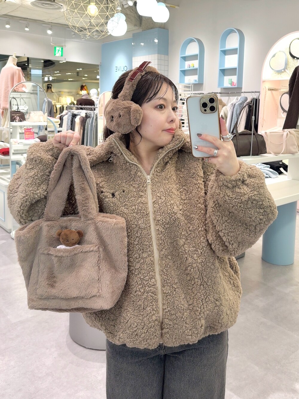 ブラウン系のブルゾン、ブラウン系のトートバッグ、ブラック系のデニムパンツを着用したレディースの冬コーディネートの2枚目の写真