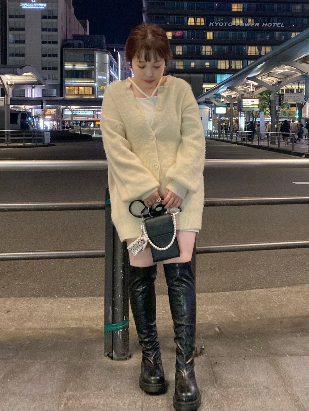 ベージュ系のカーディガン/ボレロ、ホワイト系のTシャツ/カットソー、ブラック系のブーツを着用したレディースの秋コーディネートの2枚目の写真