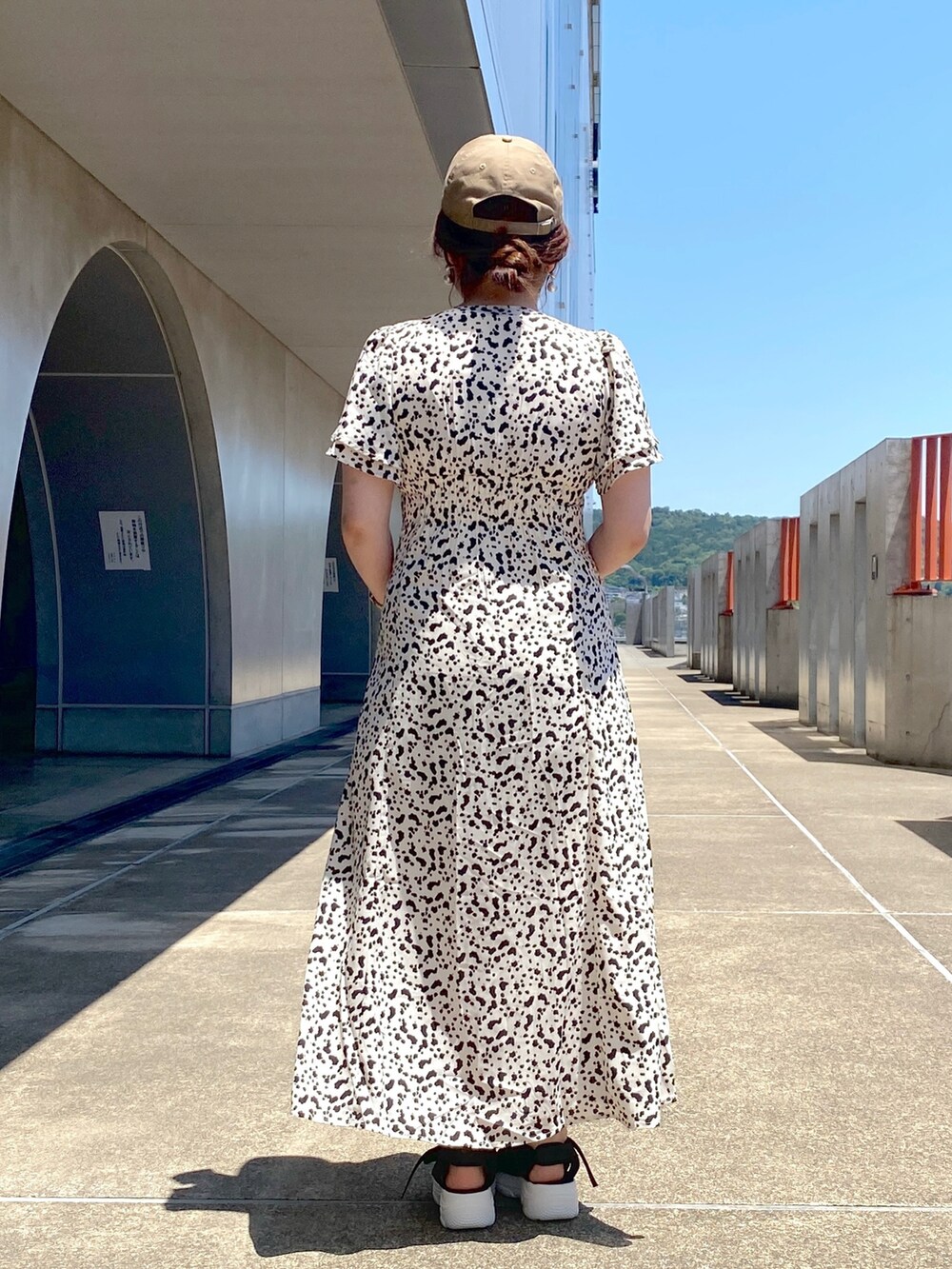 ホワイト系のワンピース、ホワイト系のショルダーバッグ、ブラック系のサンダルを着用したレディースの夏コーディネートの4枚目の写真