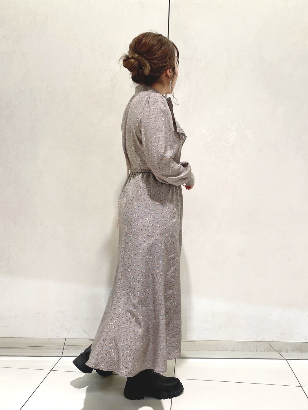 ブルー系のワンピース、ホワイト系のショルダーバッグ、ブラック系のブーツを着用したレディースの冬コーディネートの2枚目の写真