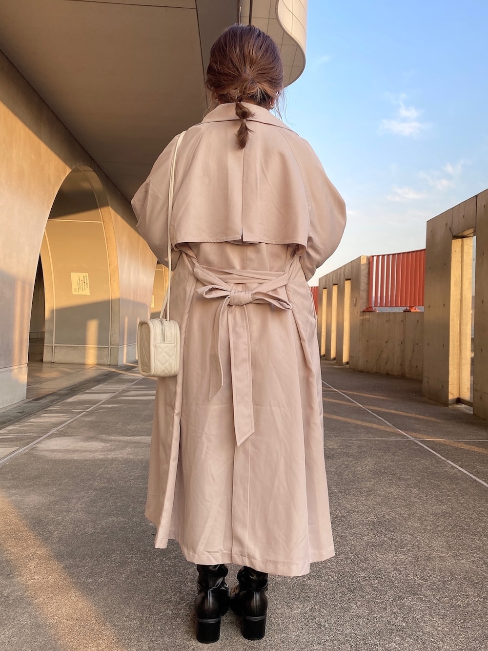 ベージュ系のトレンチコート、ホワイト系のスウェット、ブルー系のTシャツ/カットソーを着用したレディースの冬コーディネートの3枚目の写真