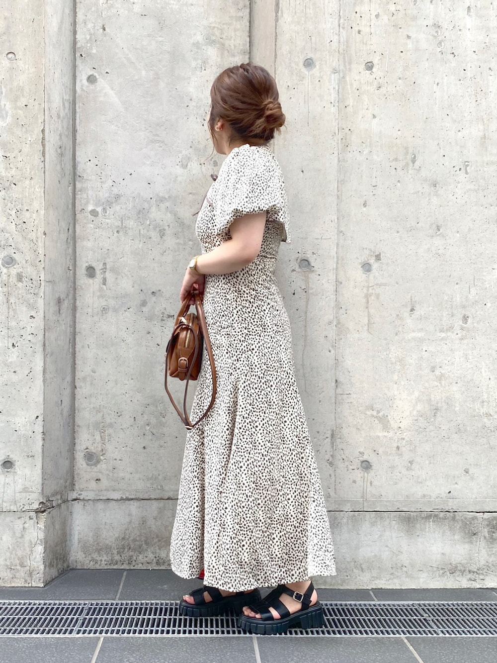 イエロー系のショルダーバッグ、ホワイト系のワンピース、ブラック系のサンダルを着用したレディースの夏コーディネートの2枚目の写真