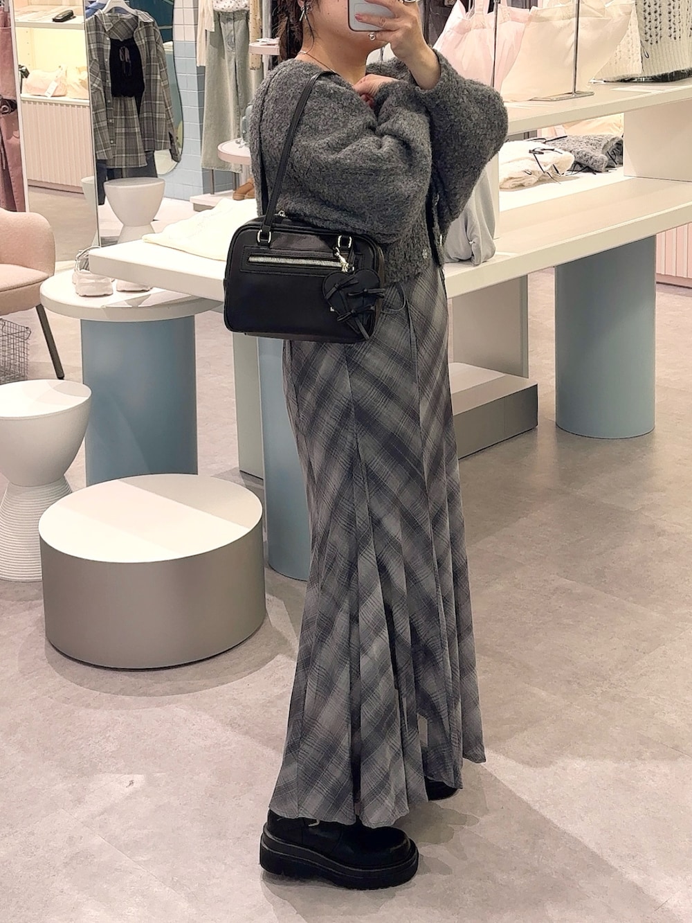 グレー系のカーディガン/ボレロ、ブラック系のワンピース、ブラック系のショルダーバッグを着用したレディースの秋コーディネートの2枚目の写真