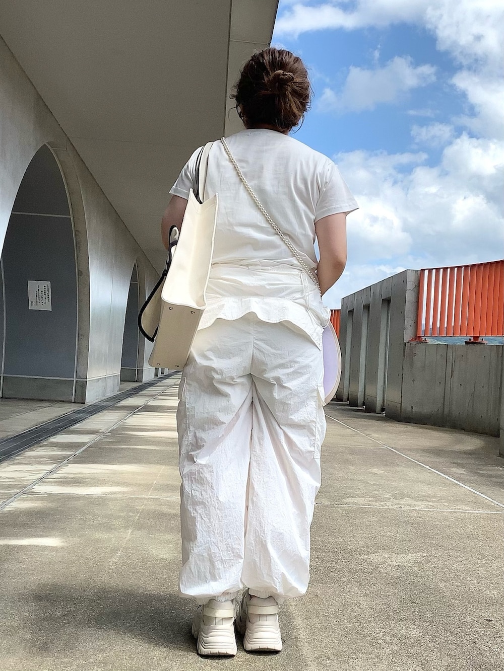 ホワイト系のTシャツ/カットソー、ホワイト系のつなぎ/オールインワン、ブラック系のトートバッグを着用したレディースの夏コーディネートの4枚目の写真