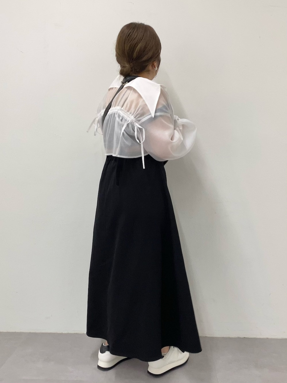 ブラック系のジャンパースカート、ブラック系のボディバッグ/ウエストポーチ、ホワイト系のシャツ/ブラウスを着用したレディースの夏コーディネートの3枚目の写真