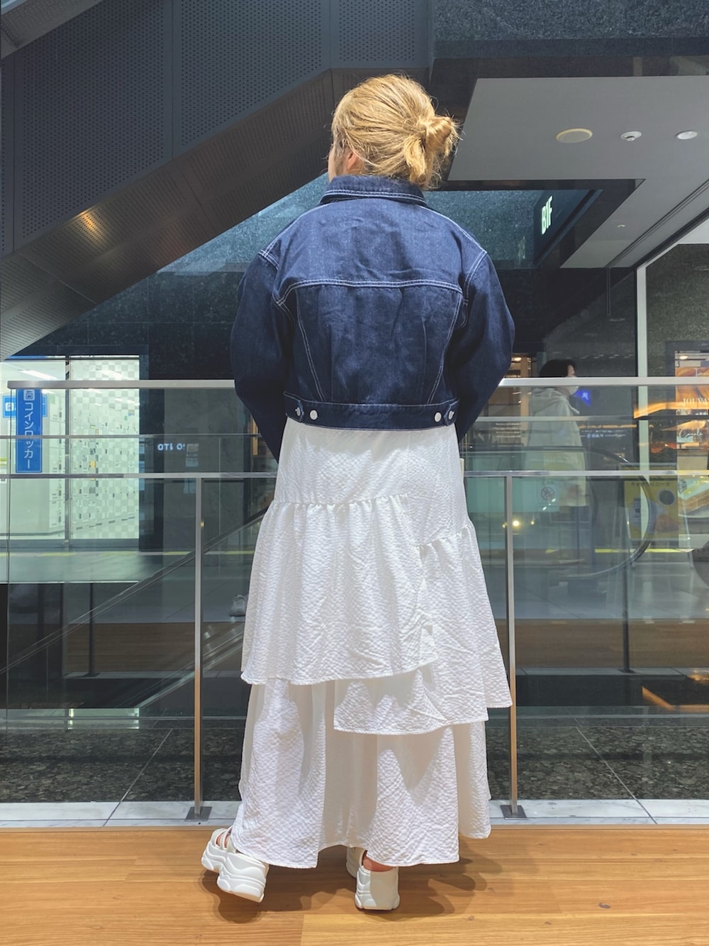 ホワイト系のスカート、ホワイト系のTシャツ/カットソー、ブルー系のデニムジャケットを着用したレディースの春コーディネートの3枚目の写真