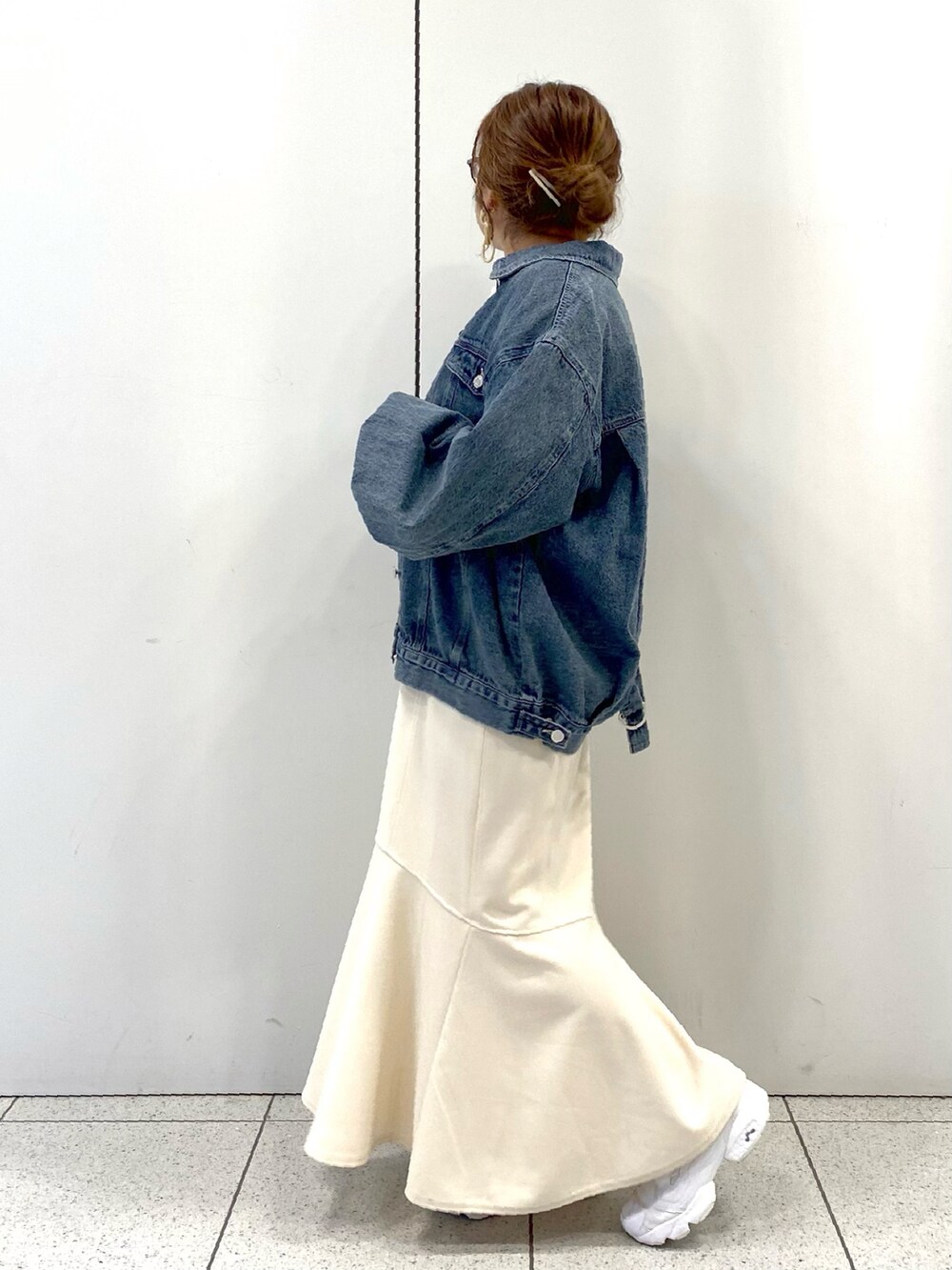 ホワイト系のスカート、ホワイト系のスニーカー、ブルー系のデニムジャケットを着用したレディースの春コーディネートの4枚目の写真