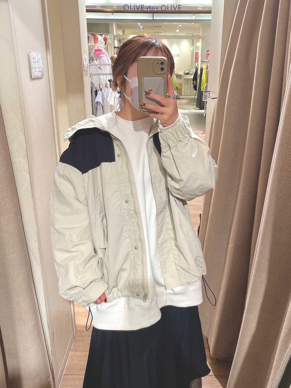 ベージュ系のマウンテンパーカー、ホワイト系のスウェット、ブラック系のスカートを着用したレディースの冬コーディネートの2枚目の写真