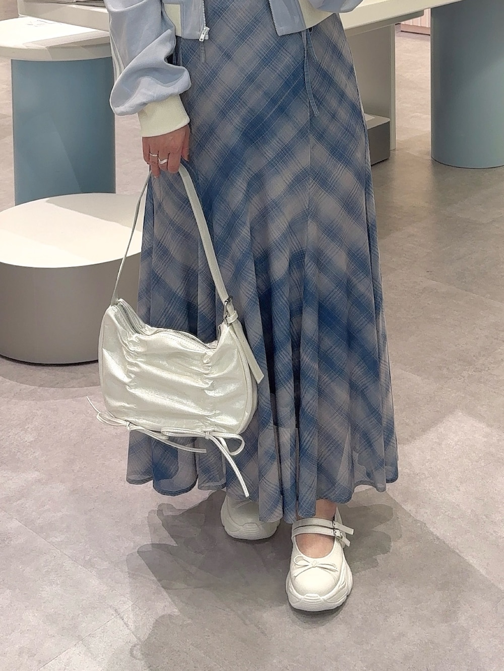 ブルー系のTシャツ/カットソー、ブラック系のワンピース、ホワイト系のショルダーバッグを着用したレディースの秋コーディネートの4枚目の写真