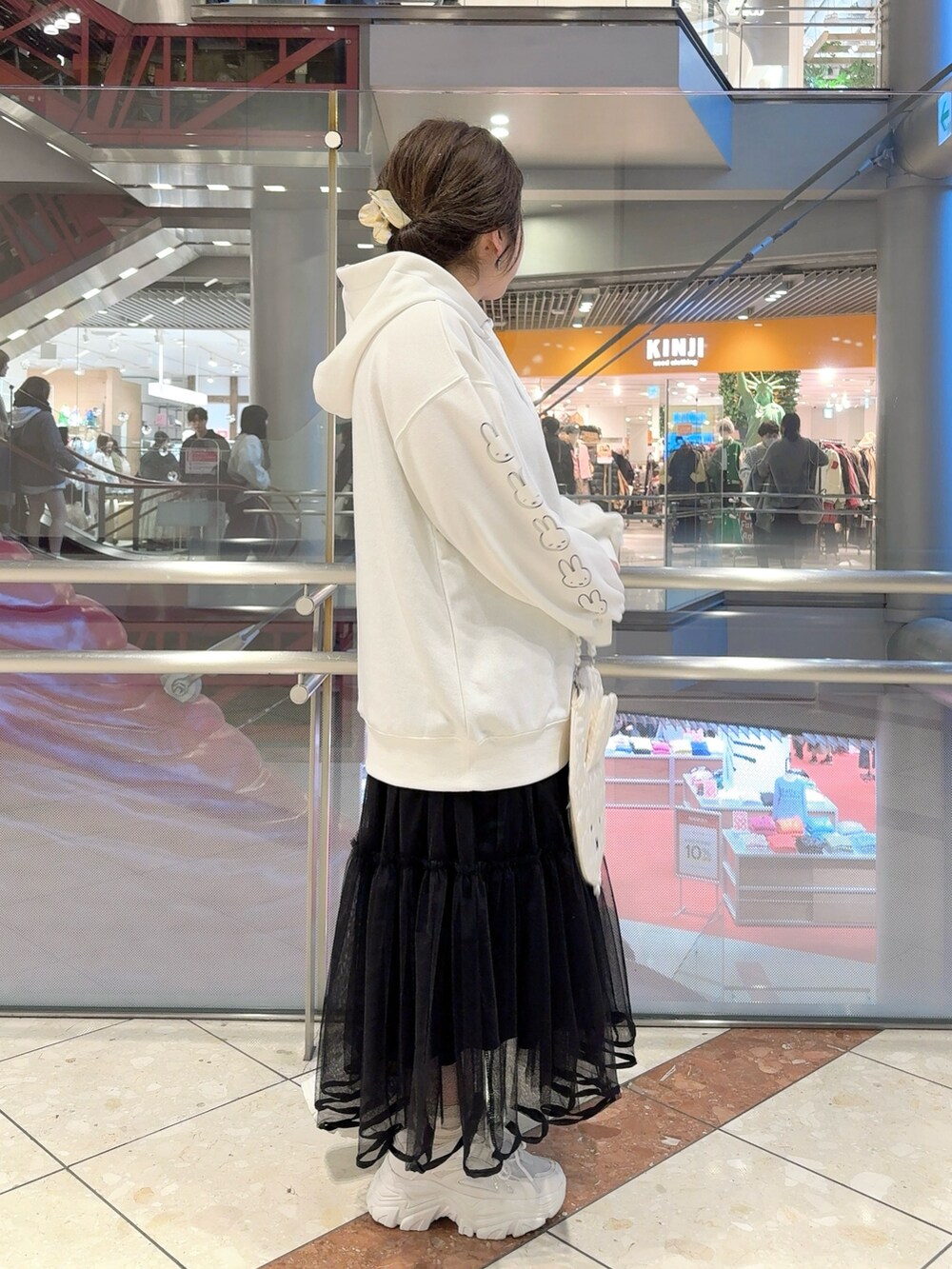 ホワイト系のパーカー、ホワイト系のショルダーバッグ、ホワイト系のハンドバッグを着用したレディースの冬コーディネートの4枚目の写真