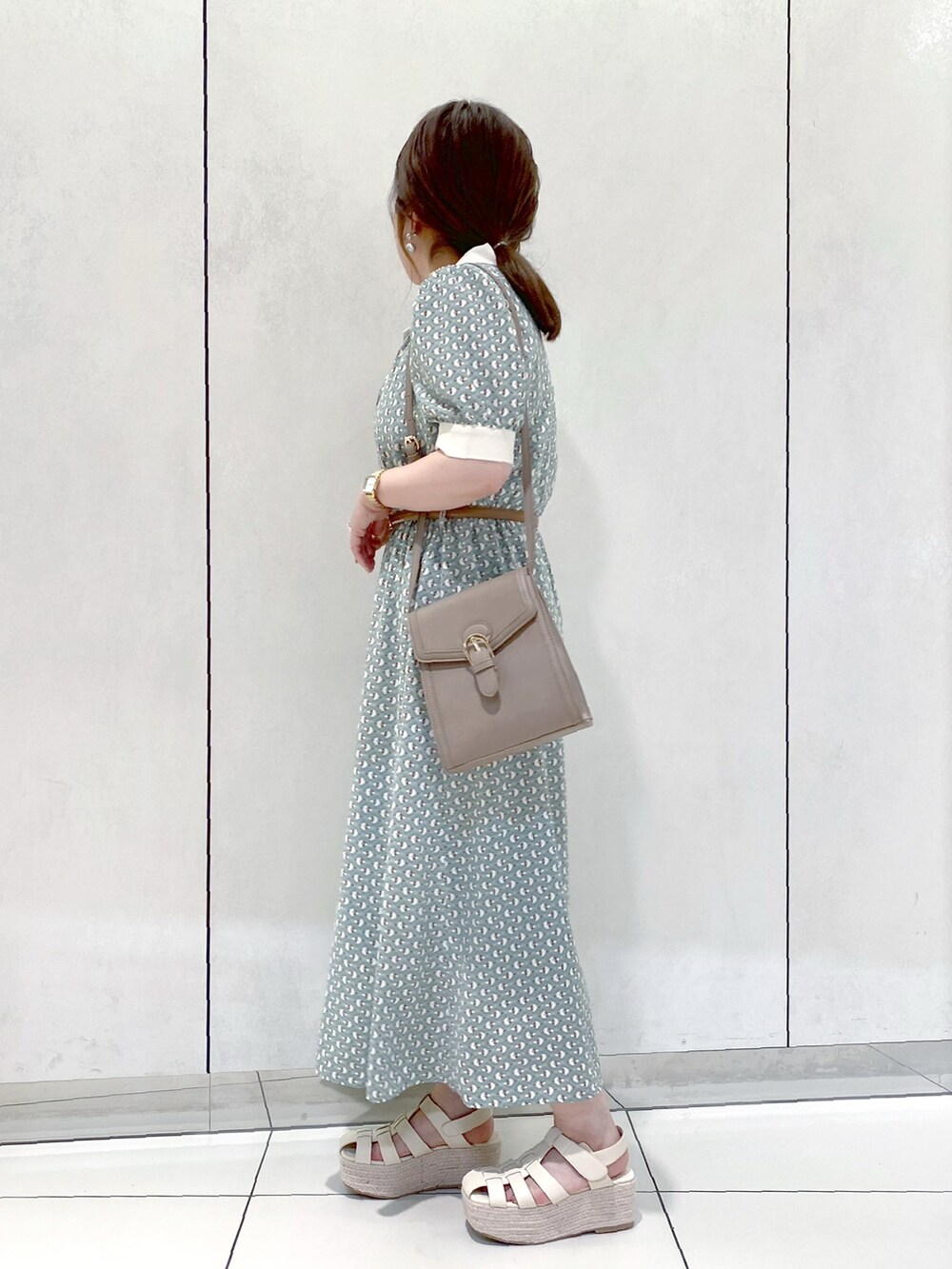 グリーン系のワンピース、ベージュ系のショルダーバッグ、ホワイト系のサンダルを着用したレディースの夏コーディネートの2枚目の写真