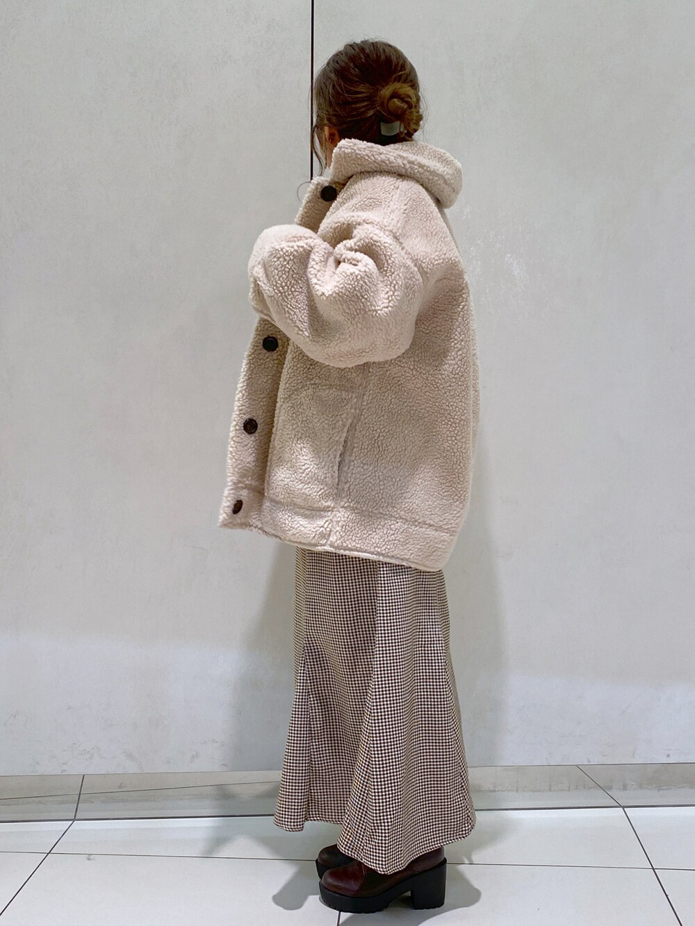 ホワイト系のニット/セーター、ベージュ系のムートンコート、ベージュ系のスカートを着用したレディースの秋コーディネートの2枚目の写真