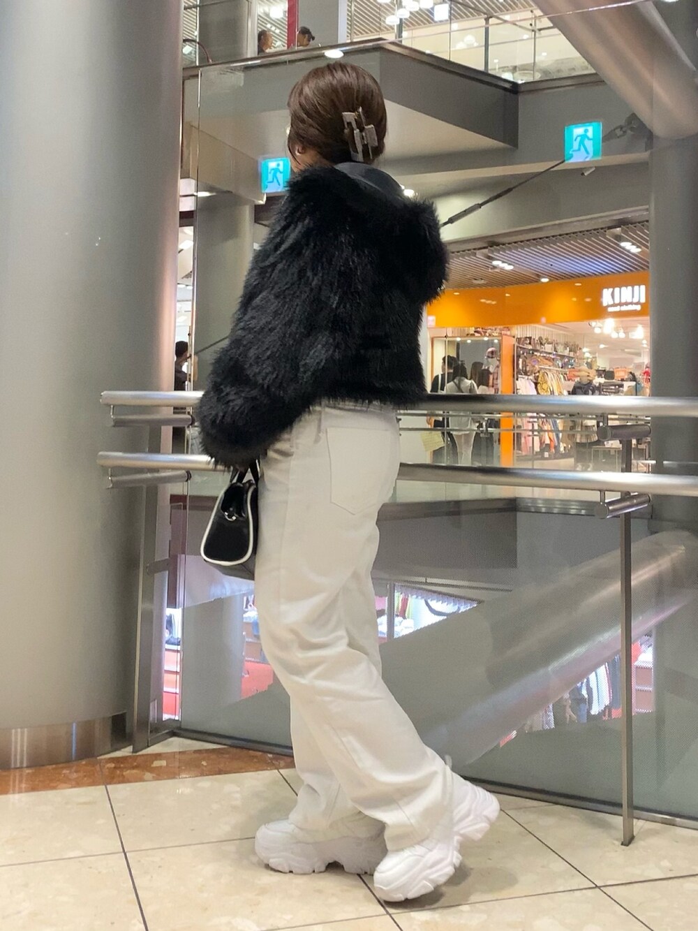 ブラック系のブルゾン、グレー系のTシャツ/カットソー、ホワイト系のデニムパンツを着用したレディースの秋コーディネートの3枚目の写真