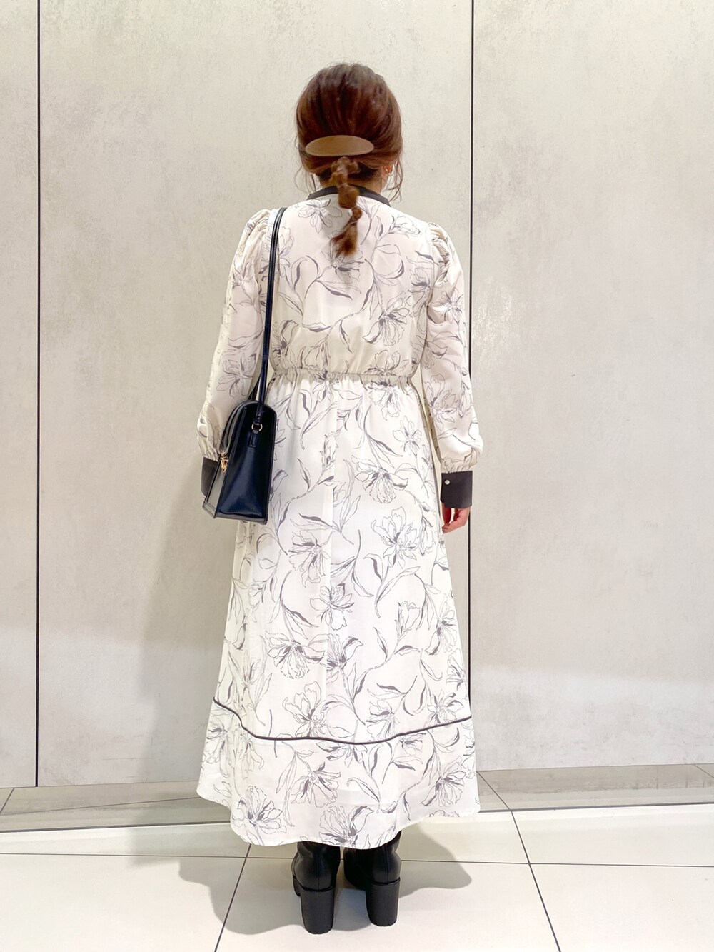 ホワイト系のワンピース、ブラック系のブーツ、ブラック系のショルダーバッグを着用したレディースの秋コーディネートの3枚目の写真