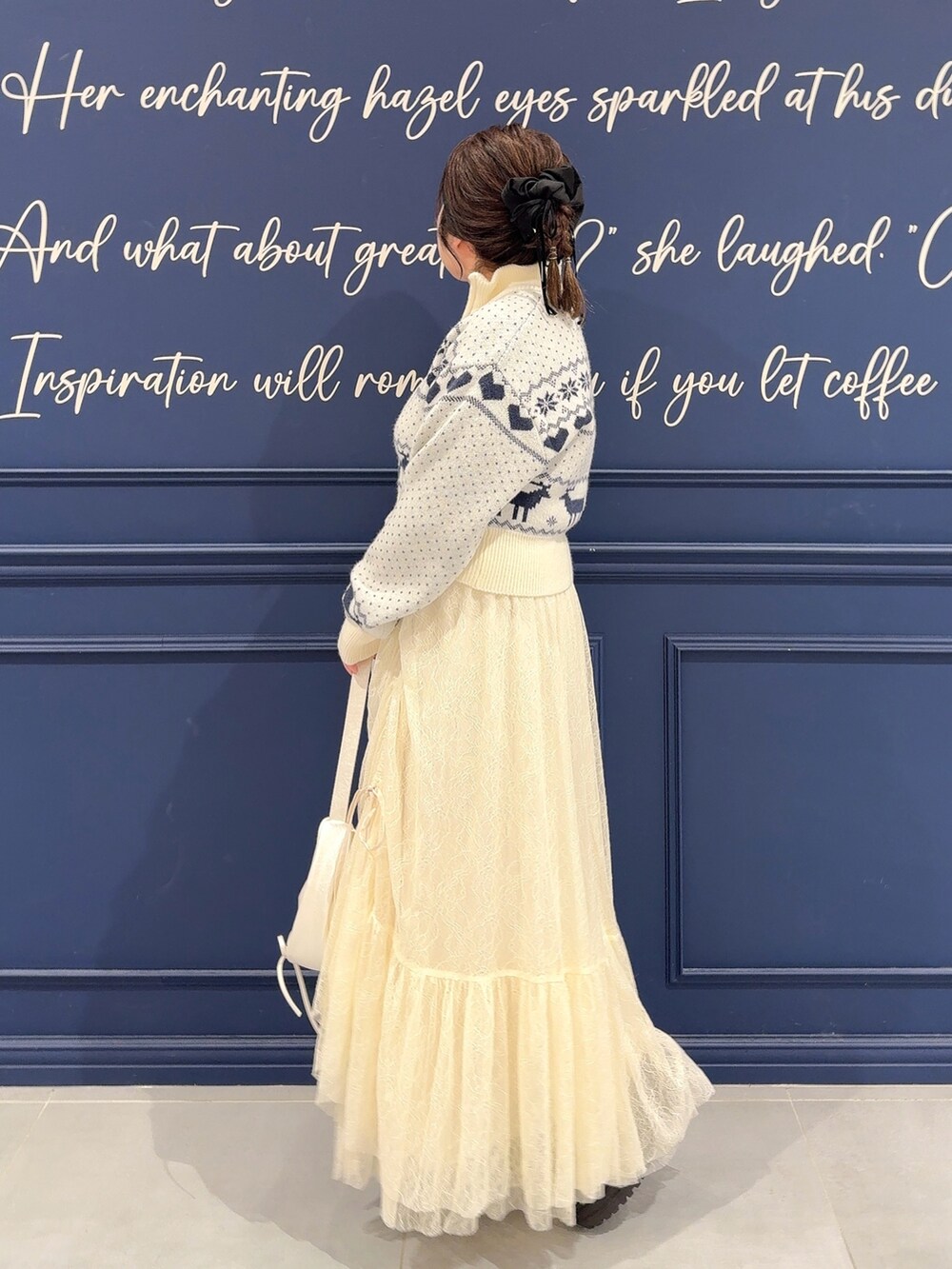 ホワイト系のカーディガン/ボレロ、ホワイト系のスカート、ブラウン系のブーツを着用したレディースの秋コーディネートの3枚目の写真