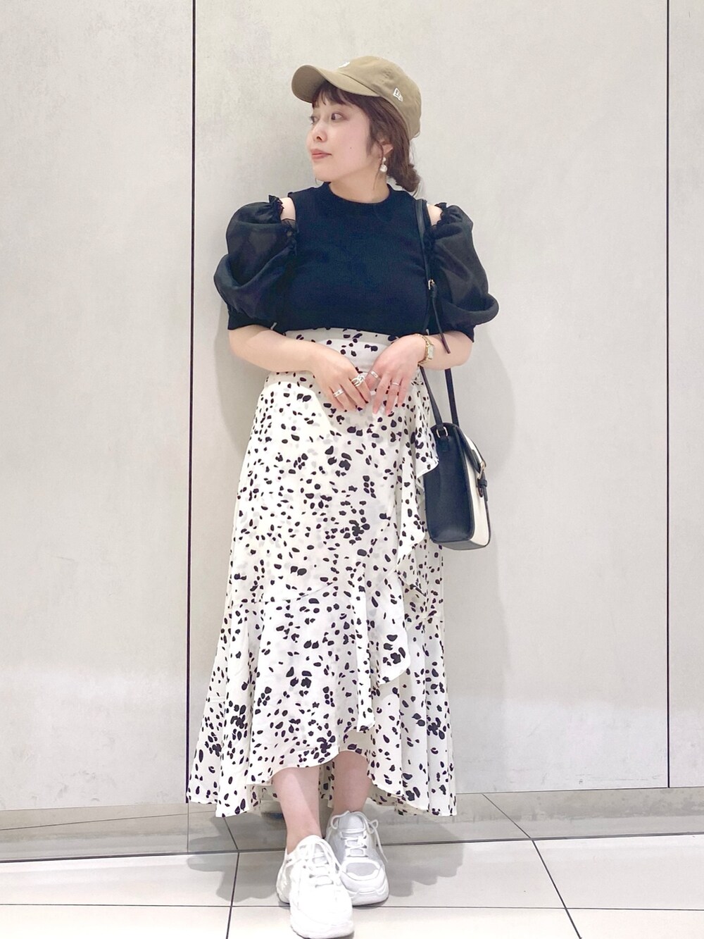 ホワイト系のスカート、ブラック系のTシャツ/カットソー、ブラック系のショルダーバッグを着用したレディースの夏コーディネートの2枚目の写真