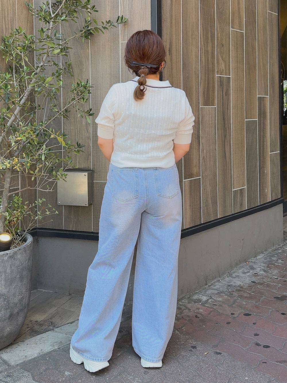 ホワイト系のニット/セーター、ブルー系のデニムパンツ、ホワイト系のショルダーバッグを着用したレディースの夏コーディネートの3枚目の写真