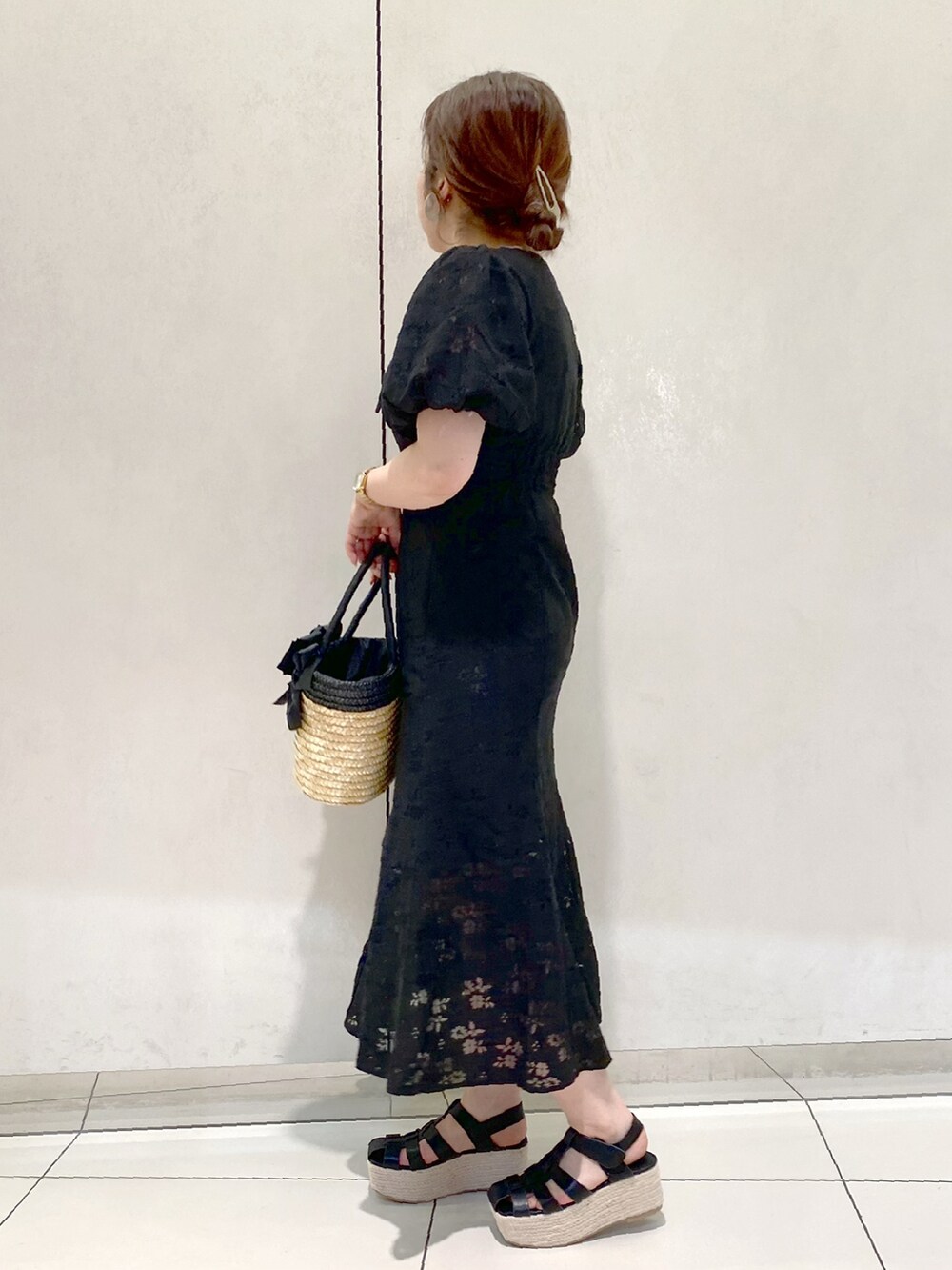 ブラック系のワンピース、ブラック系のかごバッグ、ブラック系のサンダルを着用したレディースの春コーディネートの3枚目の写真
