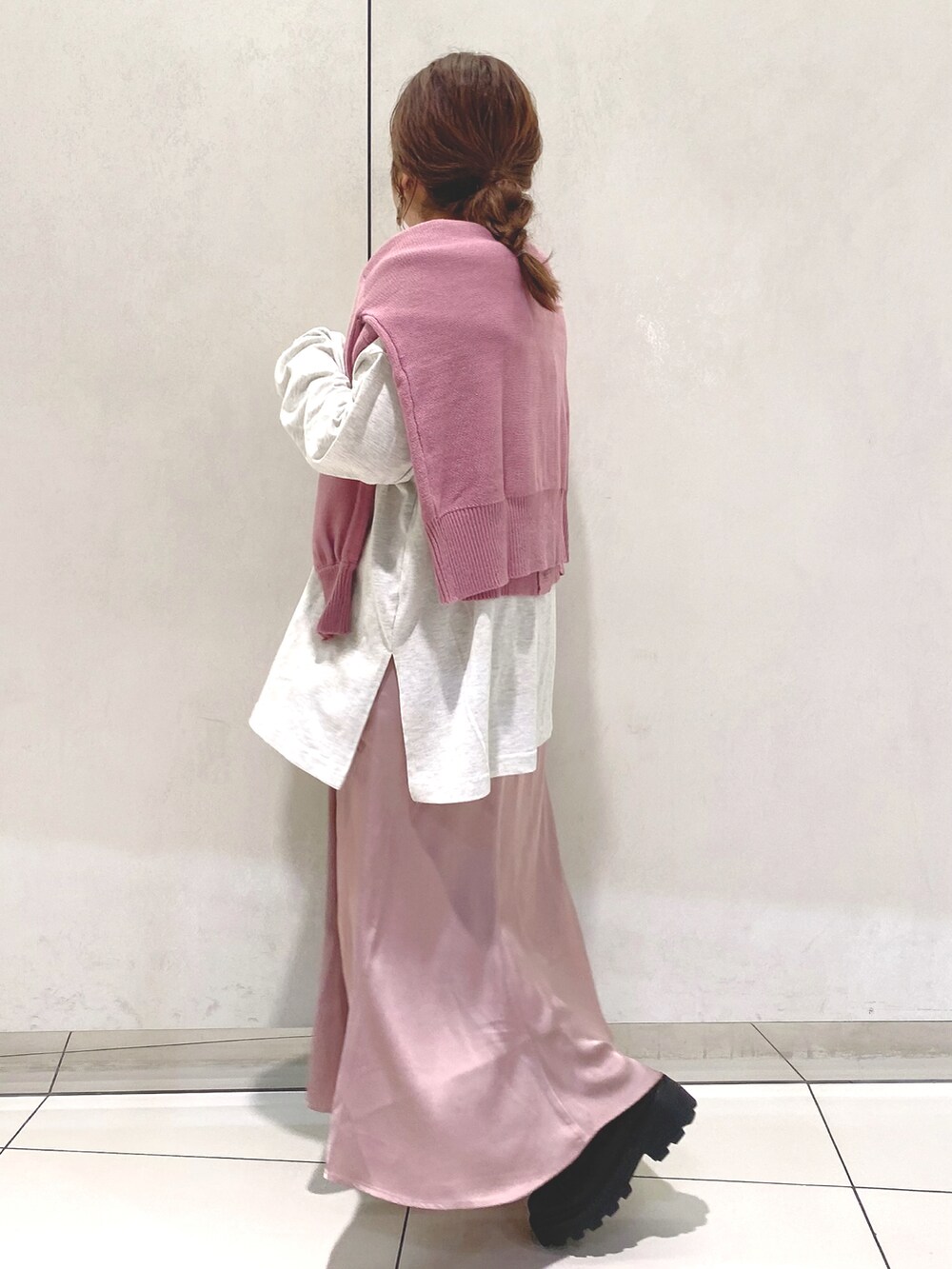 ピンク系のスカート、ブラック系のブーツ、グレー系のTシャツ/カットソーを着用したレディースの冬コーディネートの2枚目の写真