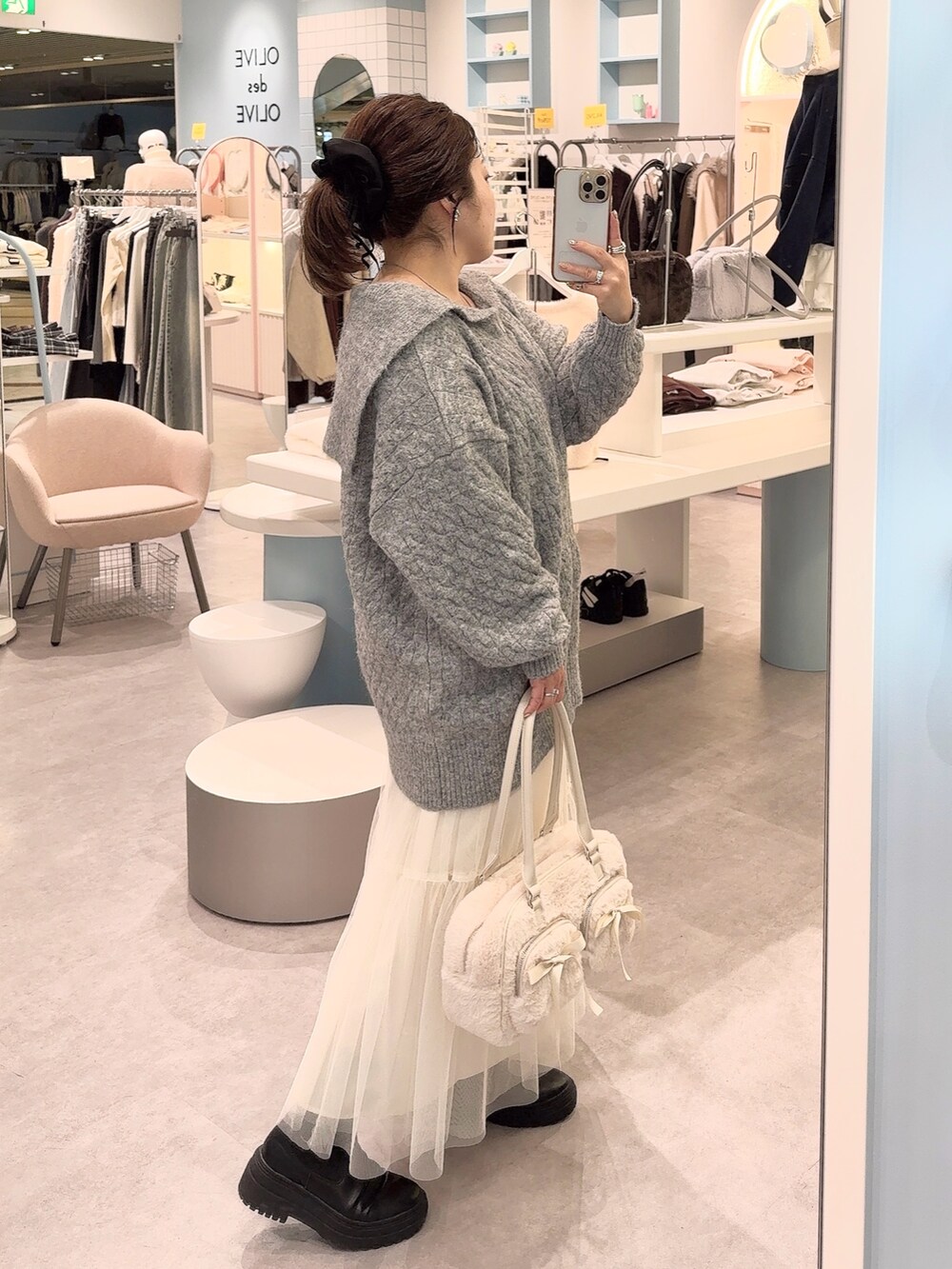 グレー系のワンピース、ホワイト系のスカート、ホワイト系のショルダーバッグを着用したレディースの冬コーディネートの3枚目の写真