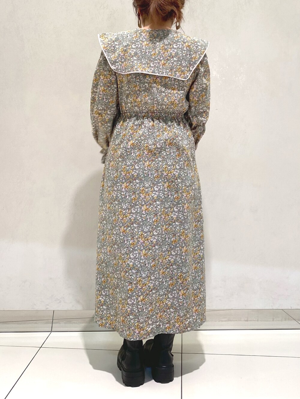 グリーン系のワンピース、ブラウン系のショルダーバッグ、ブラック系のブーツを着用したレディースの冬コーディネートの3枚目の写真