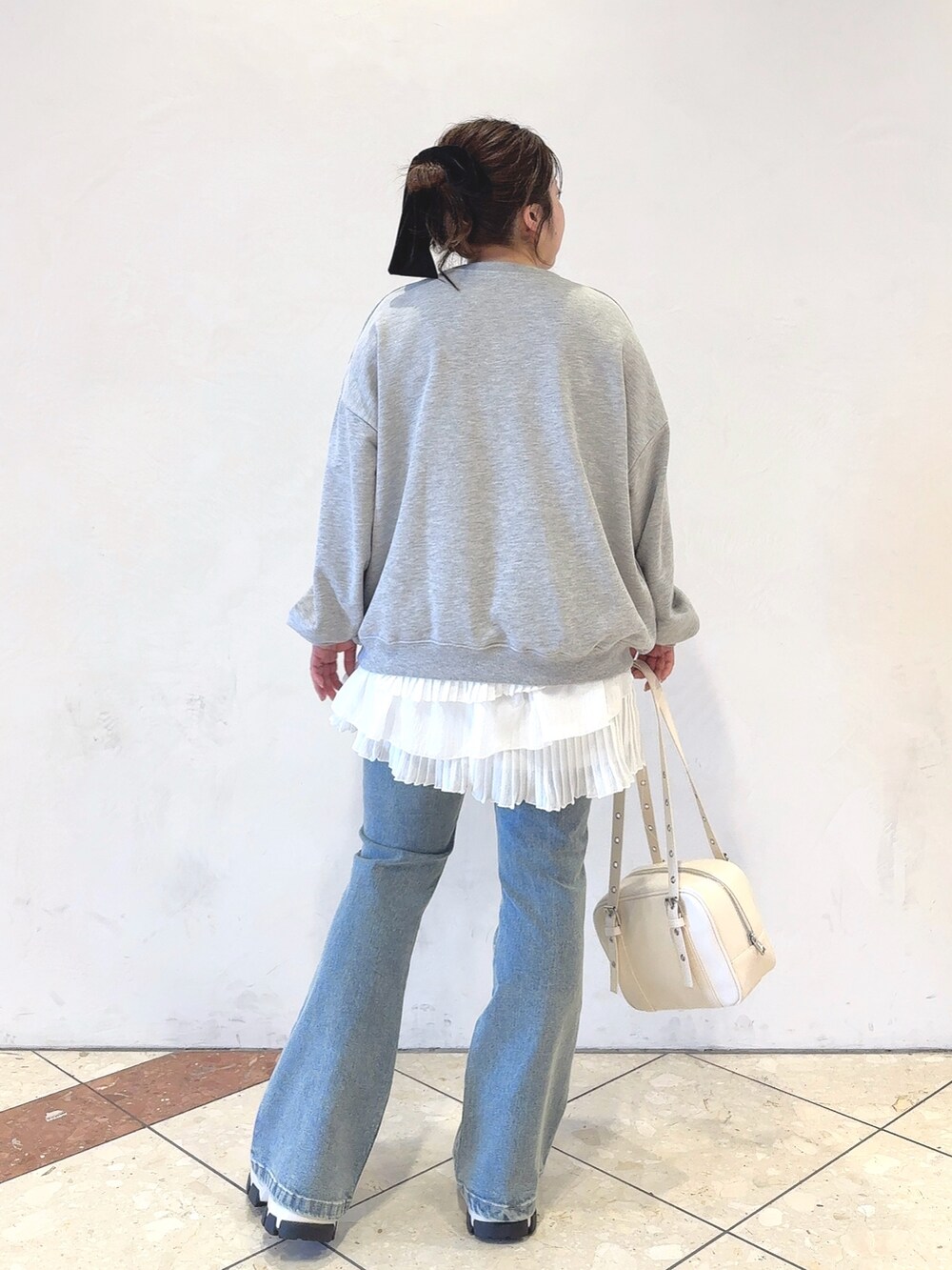 グレー系のTシャツ/カットソー、ホワイト系のワンピース、ホワイト系のショルダーバッグを着用したレディースの冬コーディネートの3枚目の写真