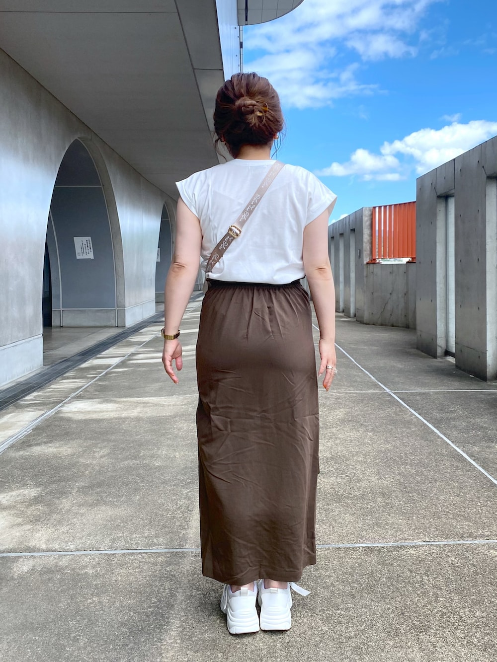 ホワイト系のTシャツ/カットソー、ブラウン系のスカート、ホワイト系のスニーカーを着用したレディースの夏コーディネートの3枚目の写真