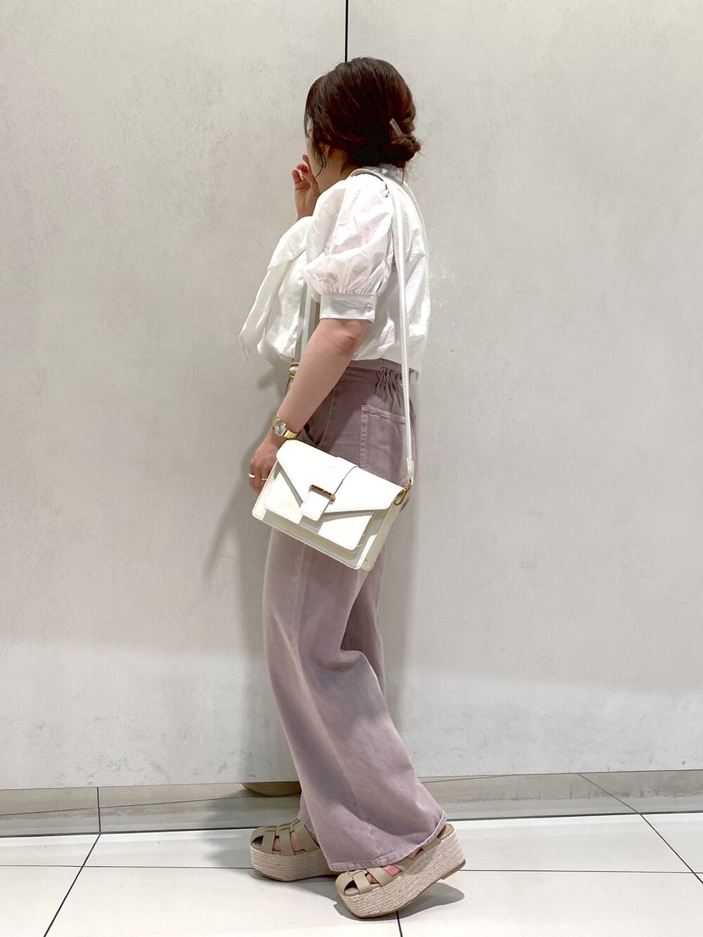 ホワイト系のショルダーバッグ、ホワイト系のシャツ/ブラウス、パープル系のデニムパンツを着用したレディースの春コーディネートの2枚目の写真