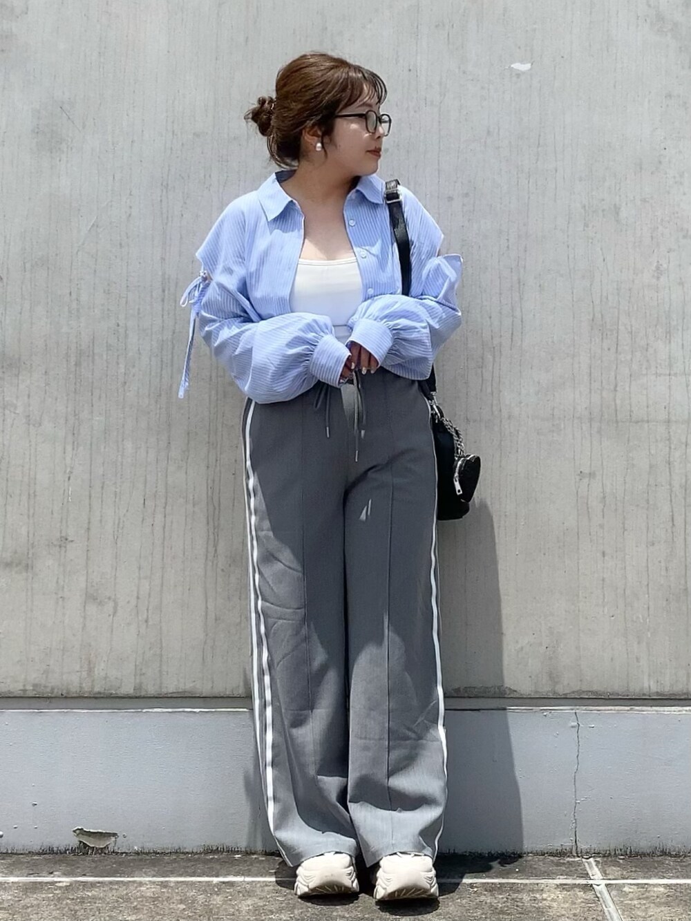 ブルー系のシャツ/ブラウス、グレー系のその他パンツ、ブラック系のショルダーバッグを着用したレディースの夏コーディネートの2枚目の写真