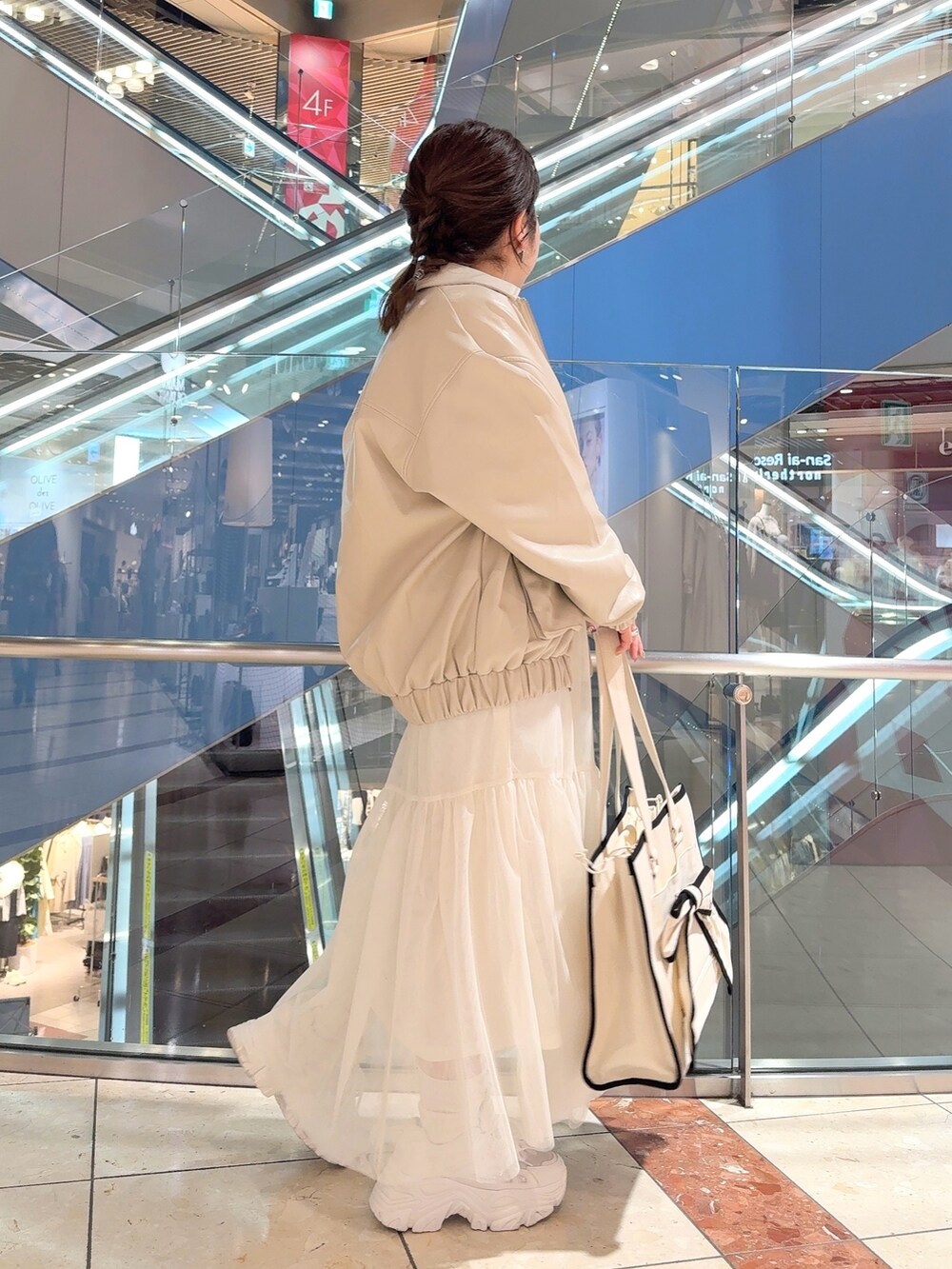 ホワイト系のブルゾン、ブルー系のワンピース、ホワイト系のトートバッグを着用したレディースの冬コーディネートの3枚目の写真