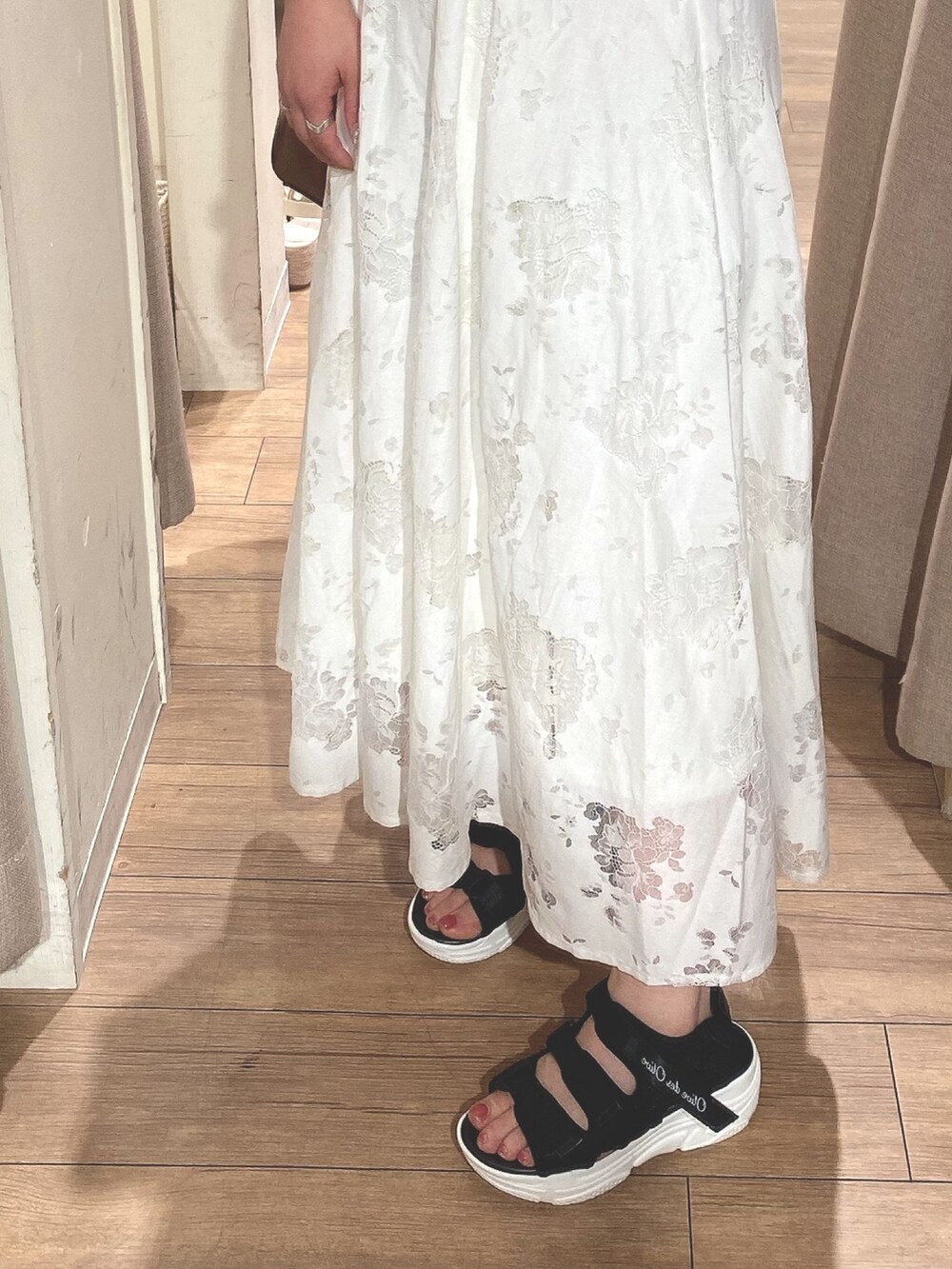 ホワイト系のスカート、ホワイト系のシャツ/ブラウス、ブラック系のサンダルを着用したレディースの春コーディネートの3枚目の写真