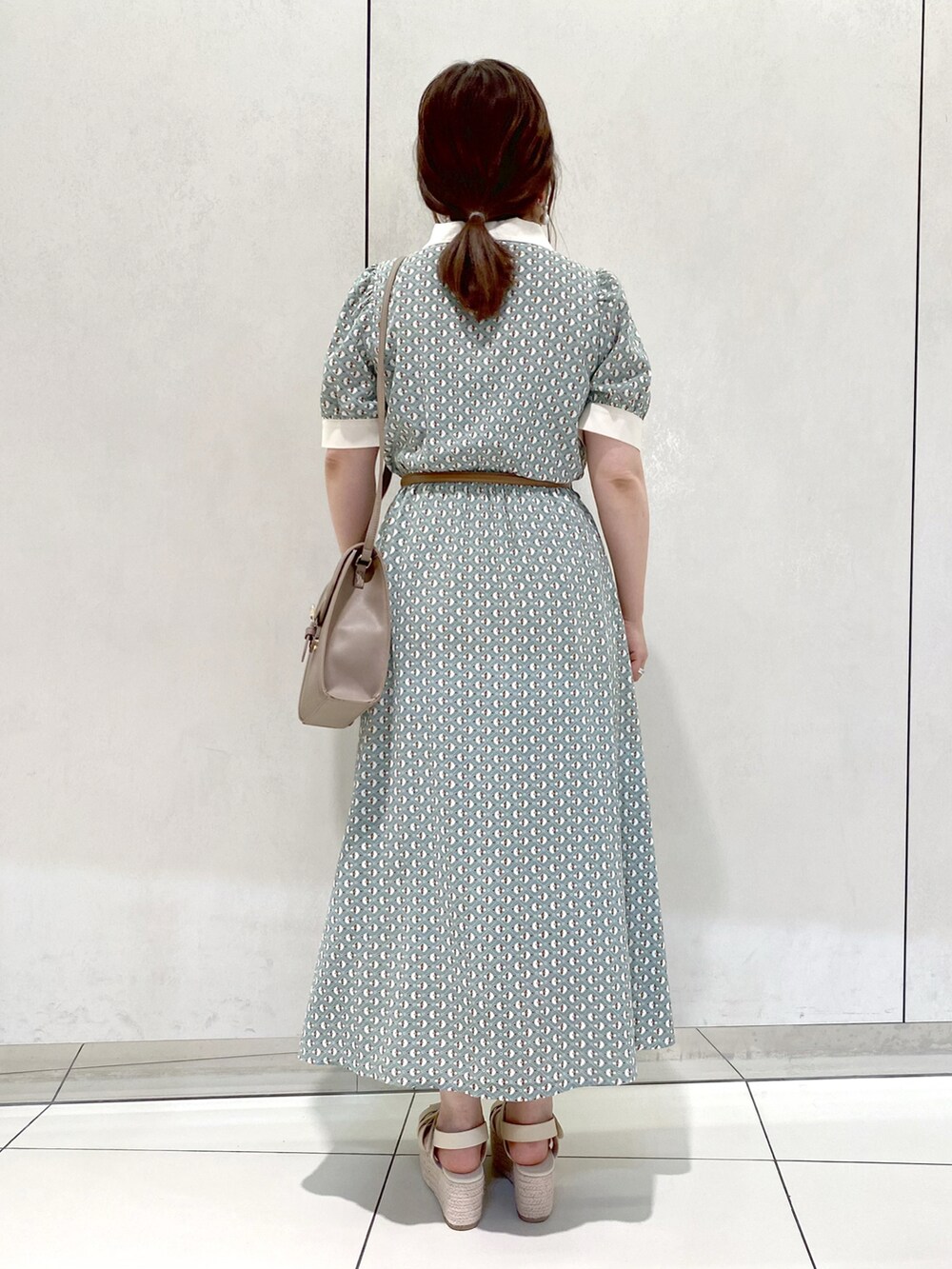 グリーン系のワンピース、ベージュ系のショルダーバッグ、ホワイト系のサンダルを着用したレディースの夏コーディネートの4枚目の写真